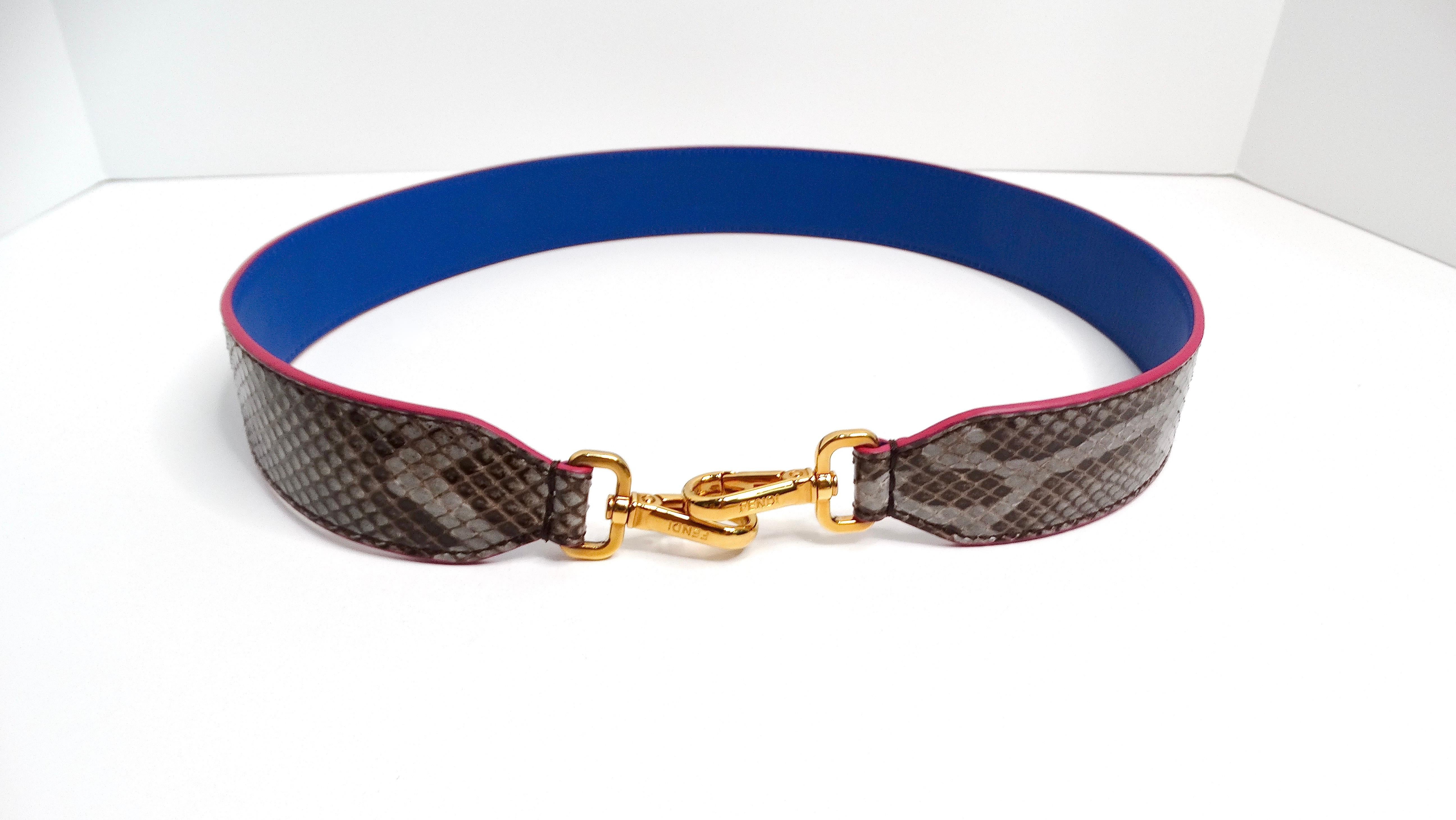 La tracolla per borsa Fendi in pelle di serpente bicolore è un accessorio lussuoso e versatile realizzato in pelle di alta qualità. Questa tracolla presenta un design accattivante con un lato rivestito in un vivace color fuschia e l'altro in un