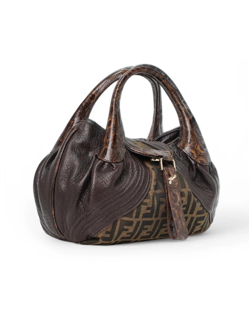 Fendi signature bag, Spy model in the small size, made of canvas in the classic FF Logomania pattern with leather inserts and gold hardware. Featuring a flap with a magnetic button closure, internally lined in beige canvas with a small pocket, the