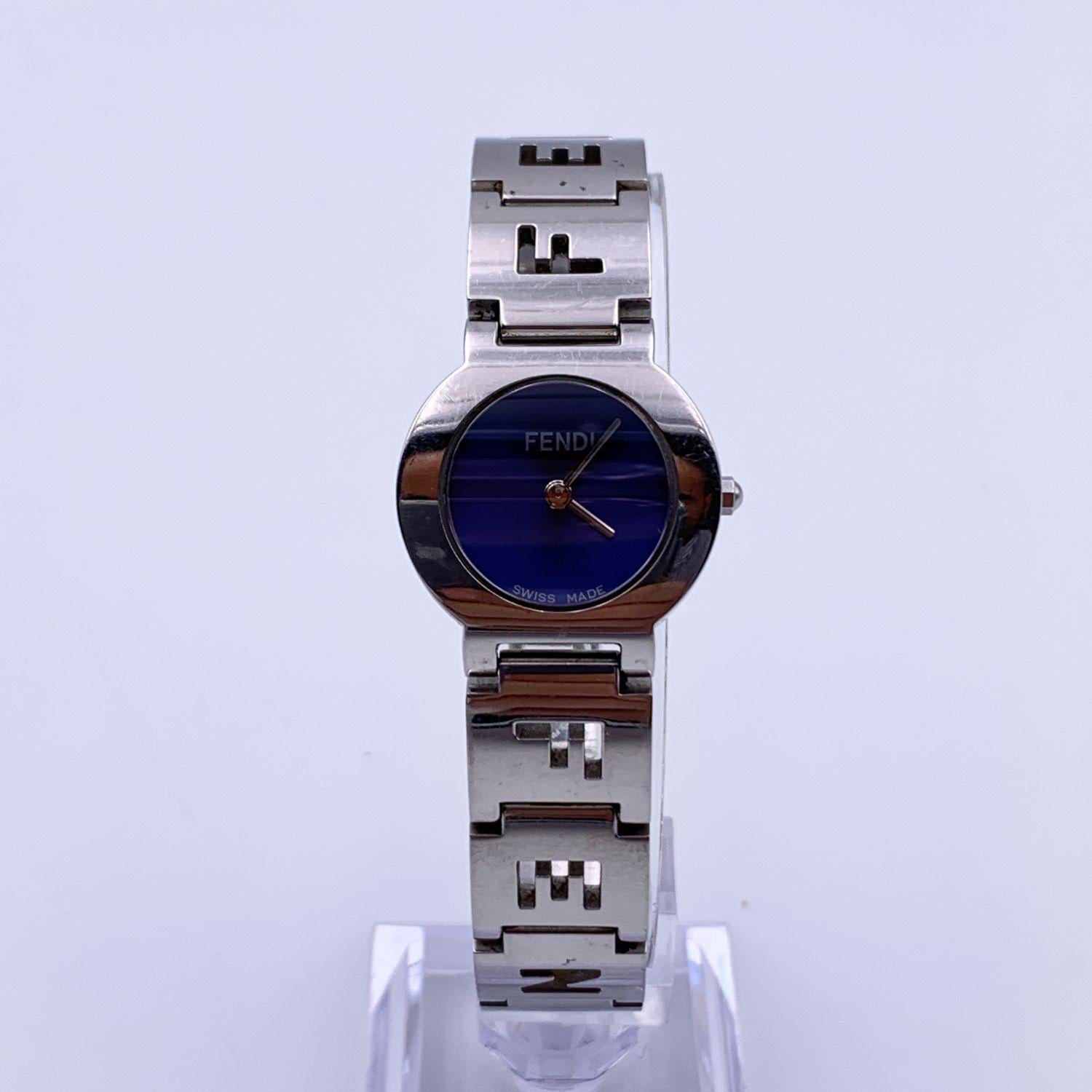Fendi silver-tone stainless steel watch, Mod. 3050 L. Round stainless steel case. Blue dial. No Hour marks. Sapphire crystal. Swiss Made Quartz movement. Fendi written on face. Silver-tone wrist strap with cut out FENDI letters. .Deployant clasp.