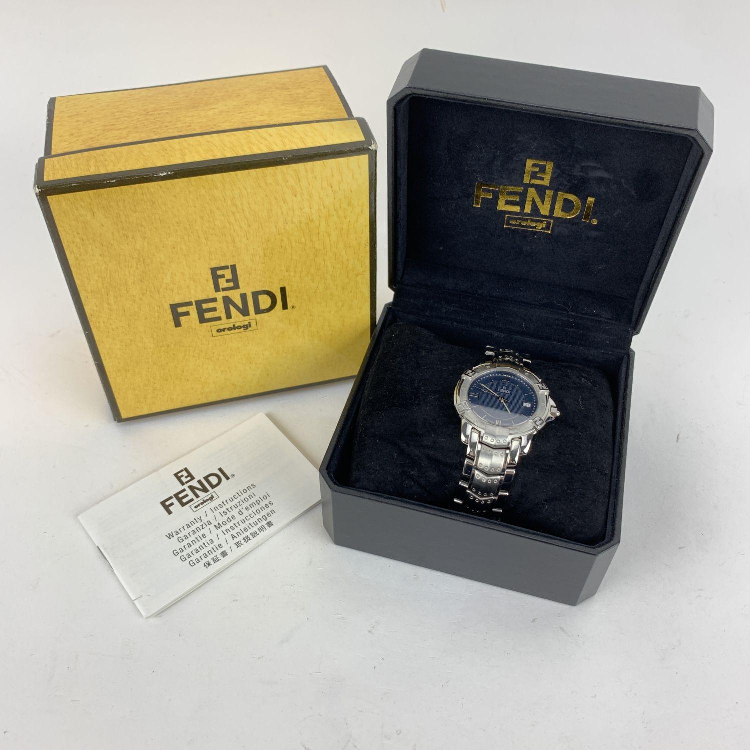 Fendi silver-tone stainless steel watch, Mod. 3500 G. Round stainless steel case. Black dial with roman numbers and three hands. Sapphire crystal. FF logos around the bezel. Date indicator. Swiss Made Quartz movement. Fendi written on face.