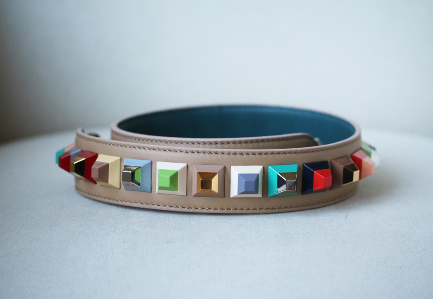 Fendi's game-changing bag straps are as coveted now as when they first launched. Backed in contrasting dark blue, this beige leather version is topped with pyramid studs and painted with orange at the edges. Beige and dark-blue leather (Calf).