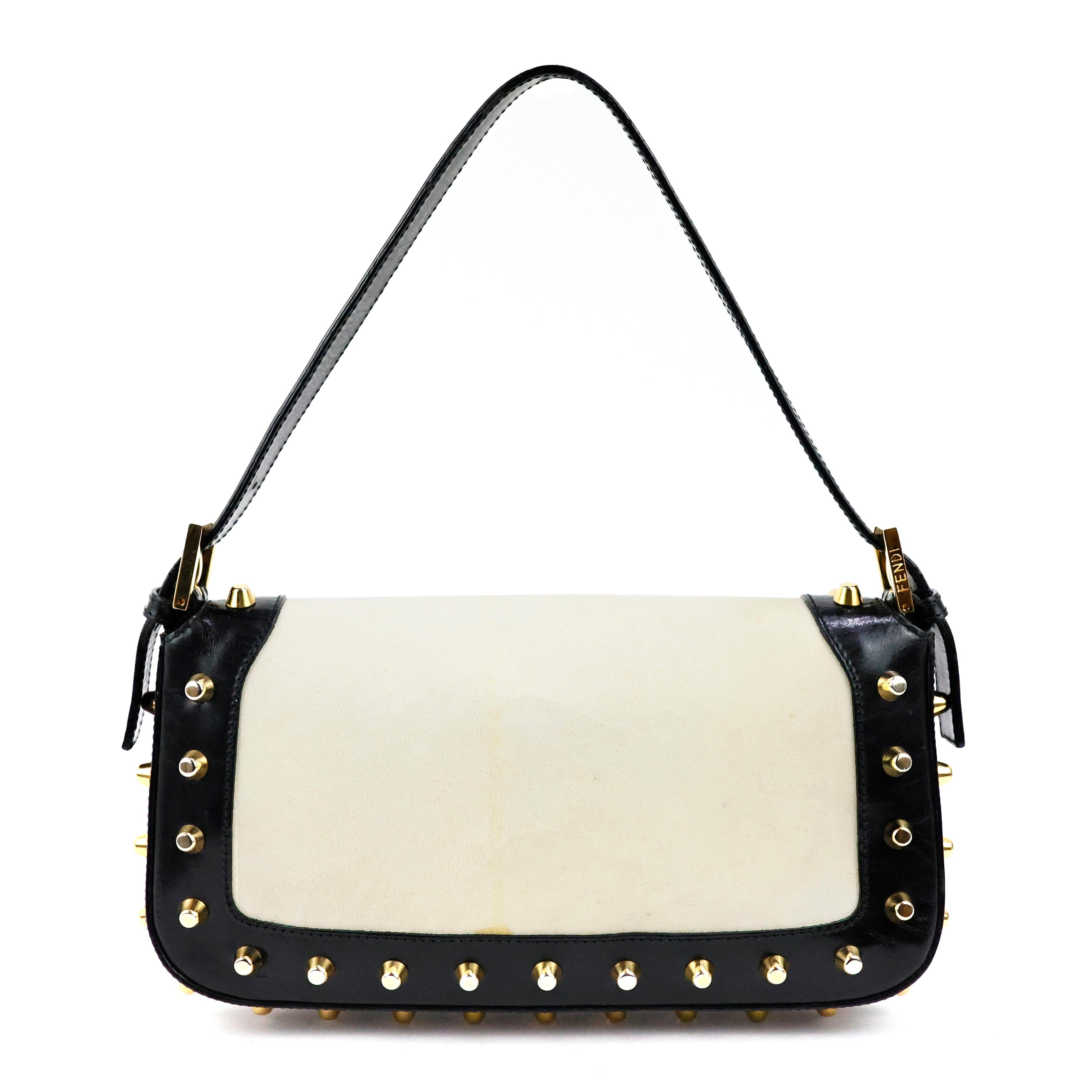 Fendi baguette studded with parchment + black calfskin leather, gold hardware.

Condition:
Good. To note: spot on the back of the bag, signs of wear on parchment.

Packing/accessories:
Dustbag.

Measurements: 
Width: 24 cm
Height: 14,5 cm
Depth: 4 cm