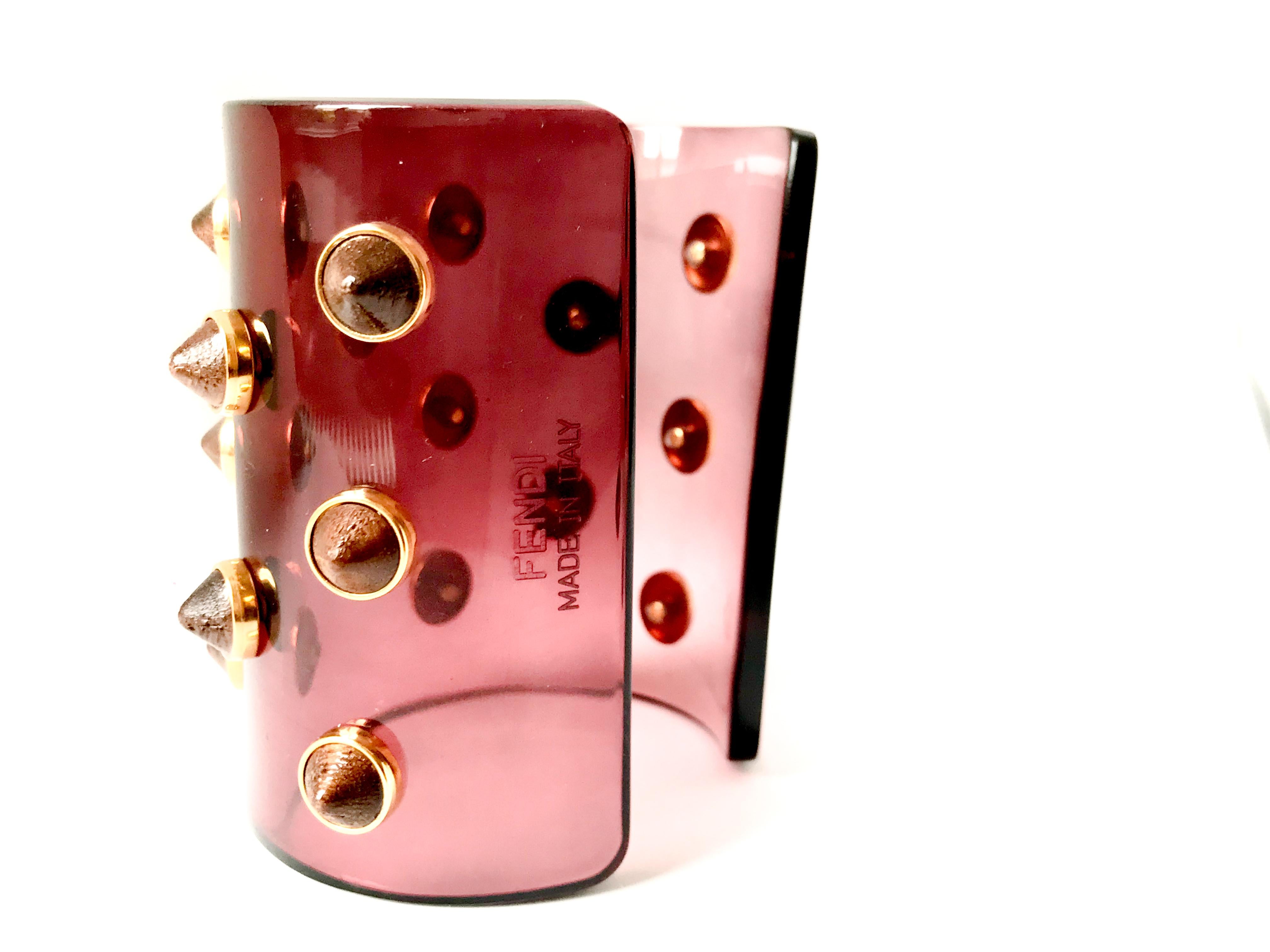 Fendi Studded Transparent Acrylic Cuff

Grape acrylic studded cuff with walnut wood and gold tone studs. 

Wear it to give your outfit edge. Signed Fendi Made in Italy.

Comes with Fendi dustbag, box and care cards.

Excellent condition.