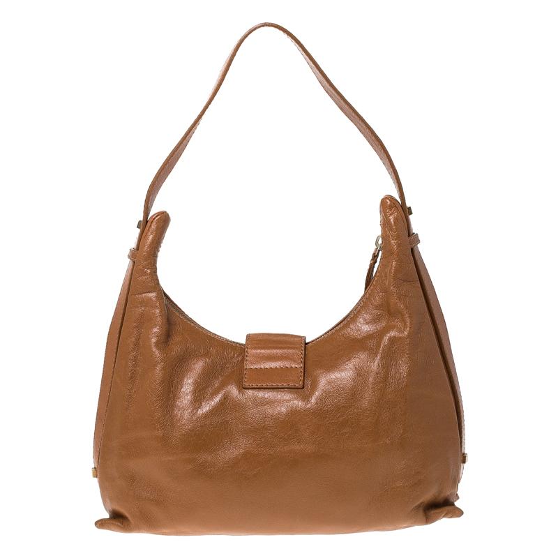 This Fendi handbag will help you create the perfect look. Made from tan leather, the bag has the FF logo on the flap and a flat handle. It flaunts a slip pocket on the front and an Alcantara lined interior that is well-sized to hold your daily
