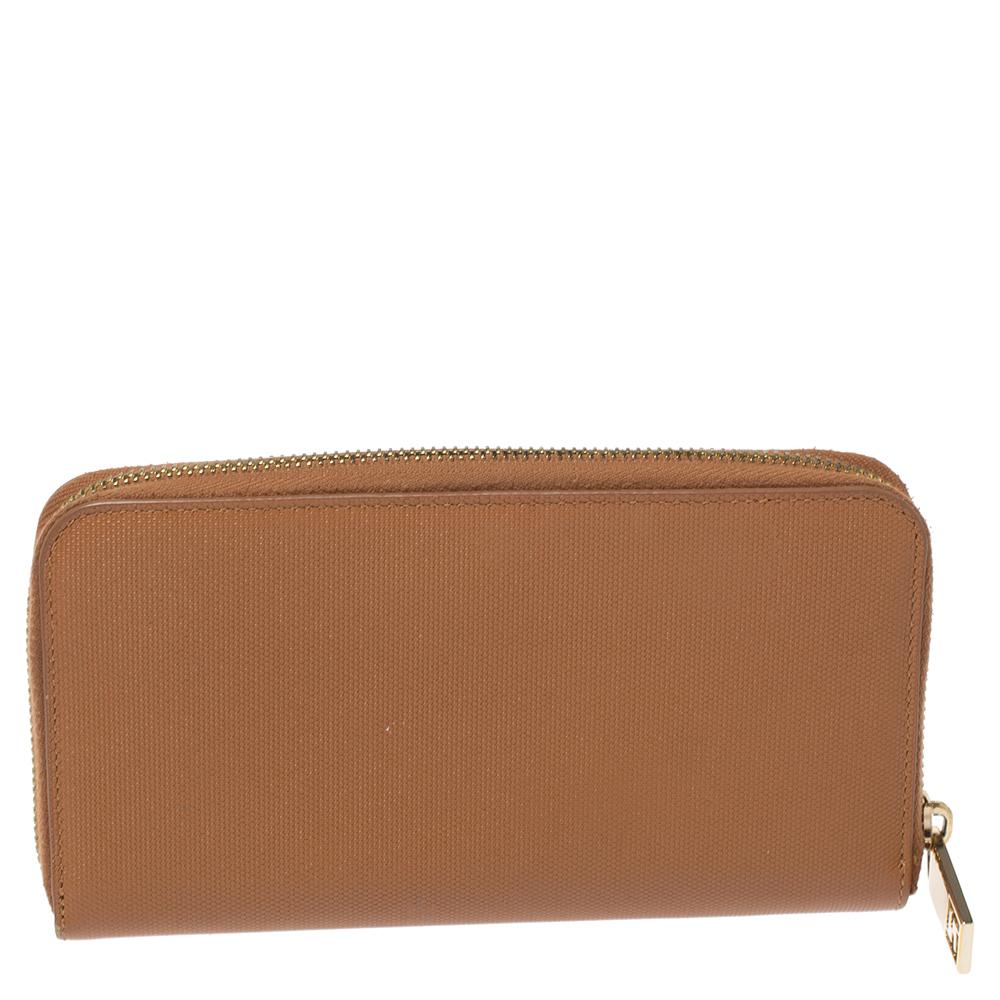 Exuding simplicity with a lot of sophistication, this zip-around wallet from Fendi is the perfect pal for your daily errands. The tan leather construction is complemented with a gold-tone brand logo detailing on the front. The zip closure opens to a