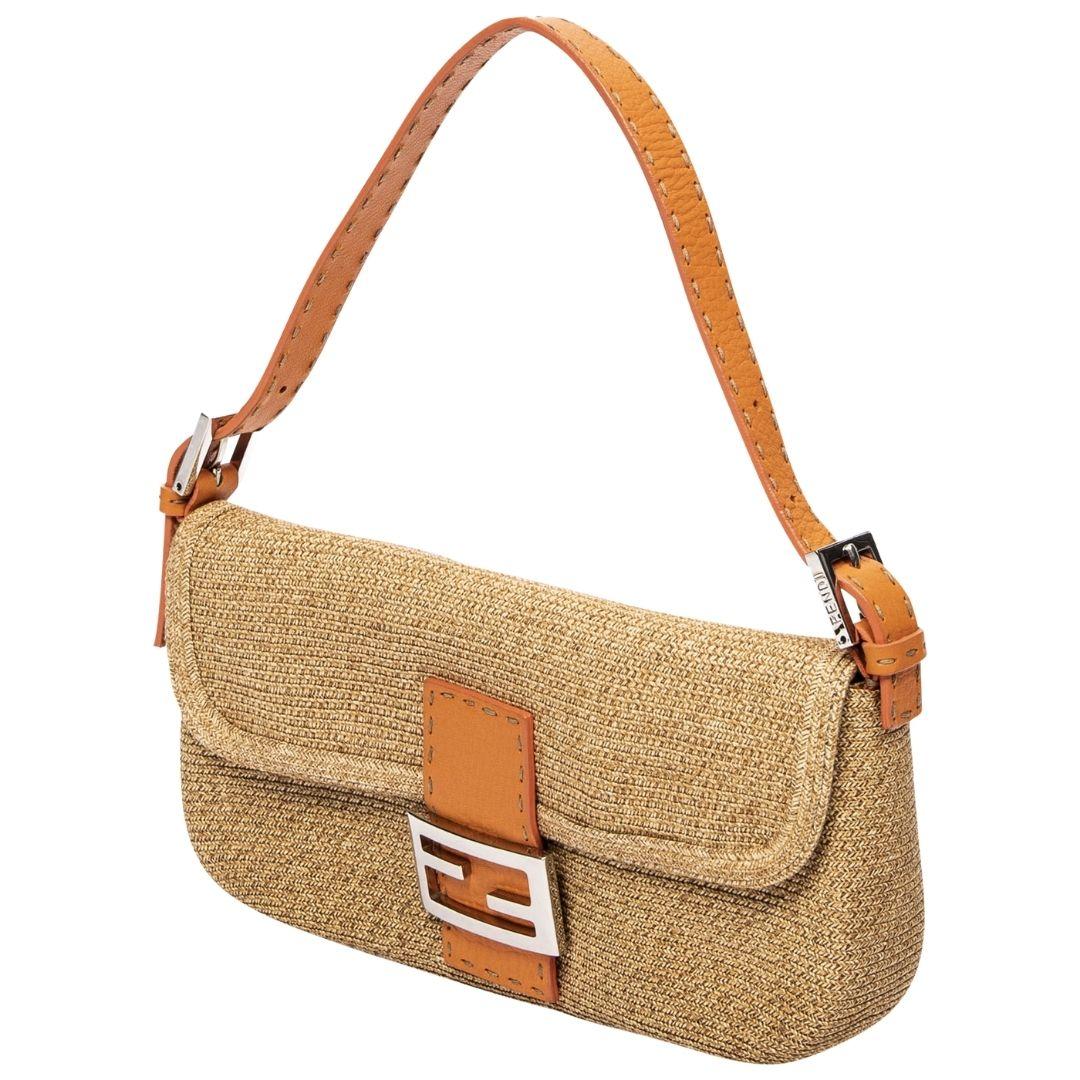 A distinctive tan and orange straw baguette with silver hardware and a magnetic snap closure. The interior is crafted from woven hemp and includes one zippered pocket.

SPECIFICS
Length: 10.2
Width: 2
Height: 5.1
Strap drop: 7
Authenticity code: