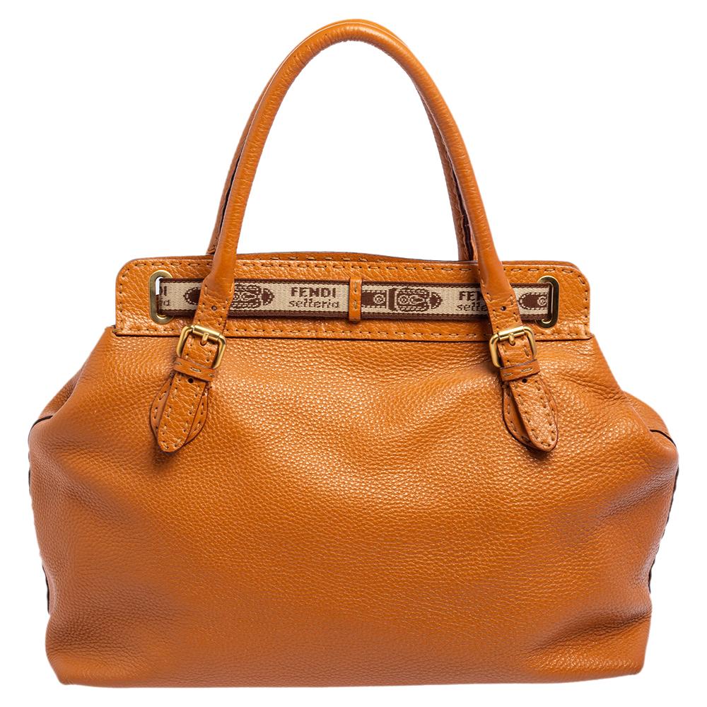 This beautiful tan Fendi Selleria Borghese bag has been skillfully crafted in leather. The exterior features an embossed horse crest at the front, a brand name tag, and rolled top leather handles. The belt and buckle details give this bag an