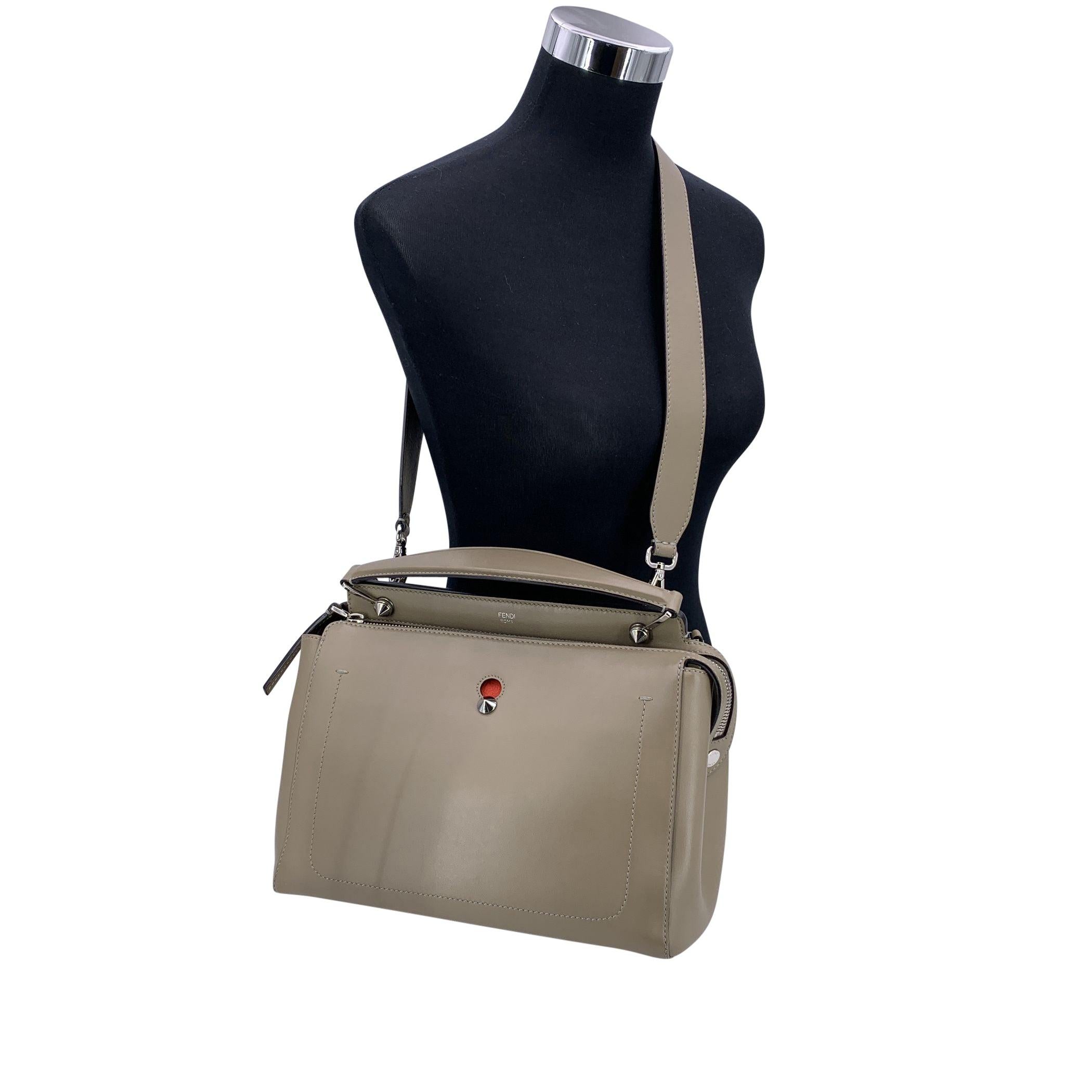 Élevez votre collection d'accessoires avec le luxueux cartable Dotcom en cuir taupe de Fendi, parfait mélange de sophistication, de praticité et d'élégance moderne. Confectionné en cuir de veau lisse dans une teinte taupe chic, ce cartable rayonne