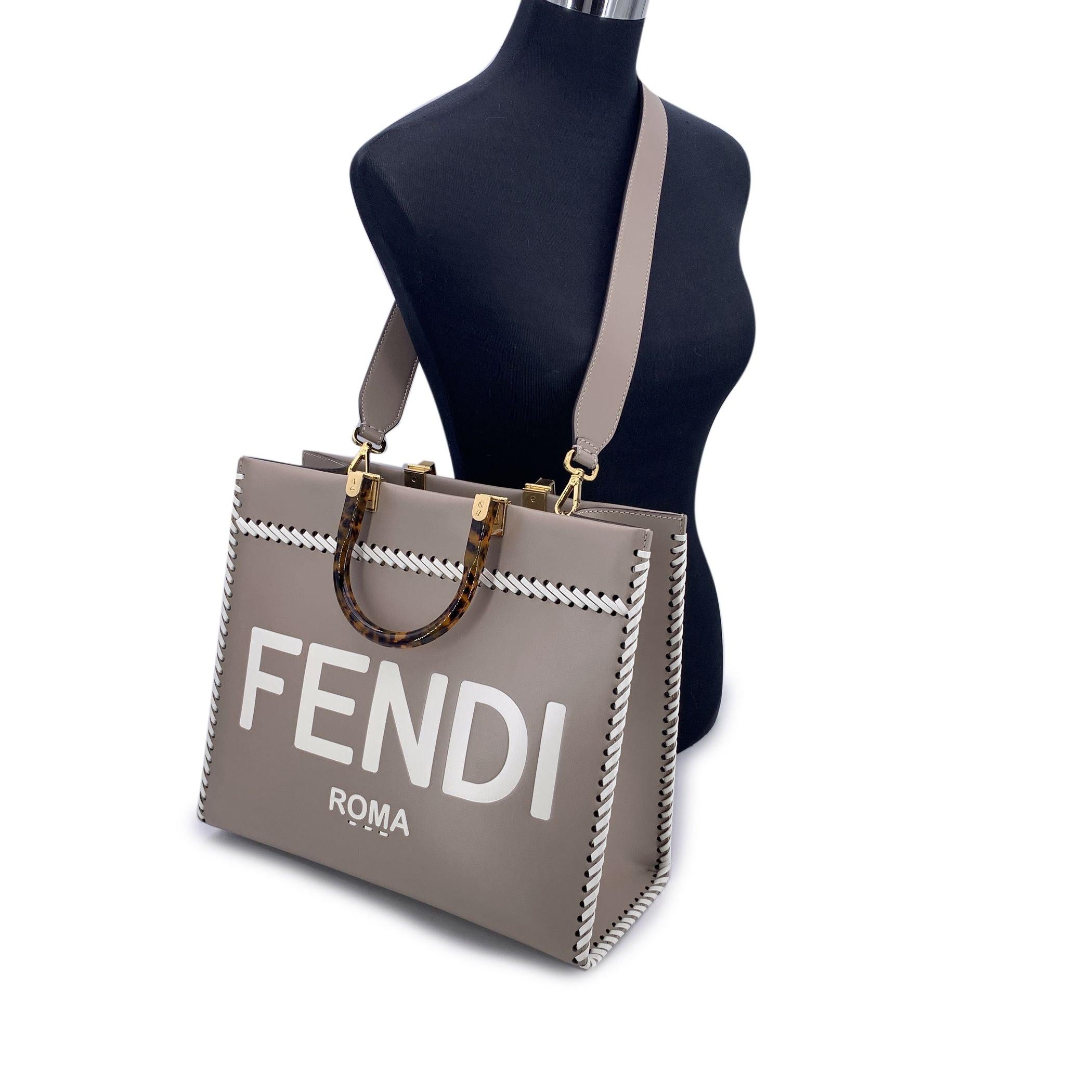 This beautiful item will come with a Certificate of Authenticity provided by Entrupy. The certificate will be provided at no further cost Sophisticated and striking, the FENDI Sunshine Medium Shopper Tote in Tortora taupe leather is a modern classic