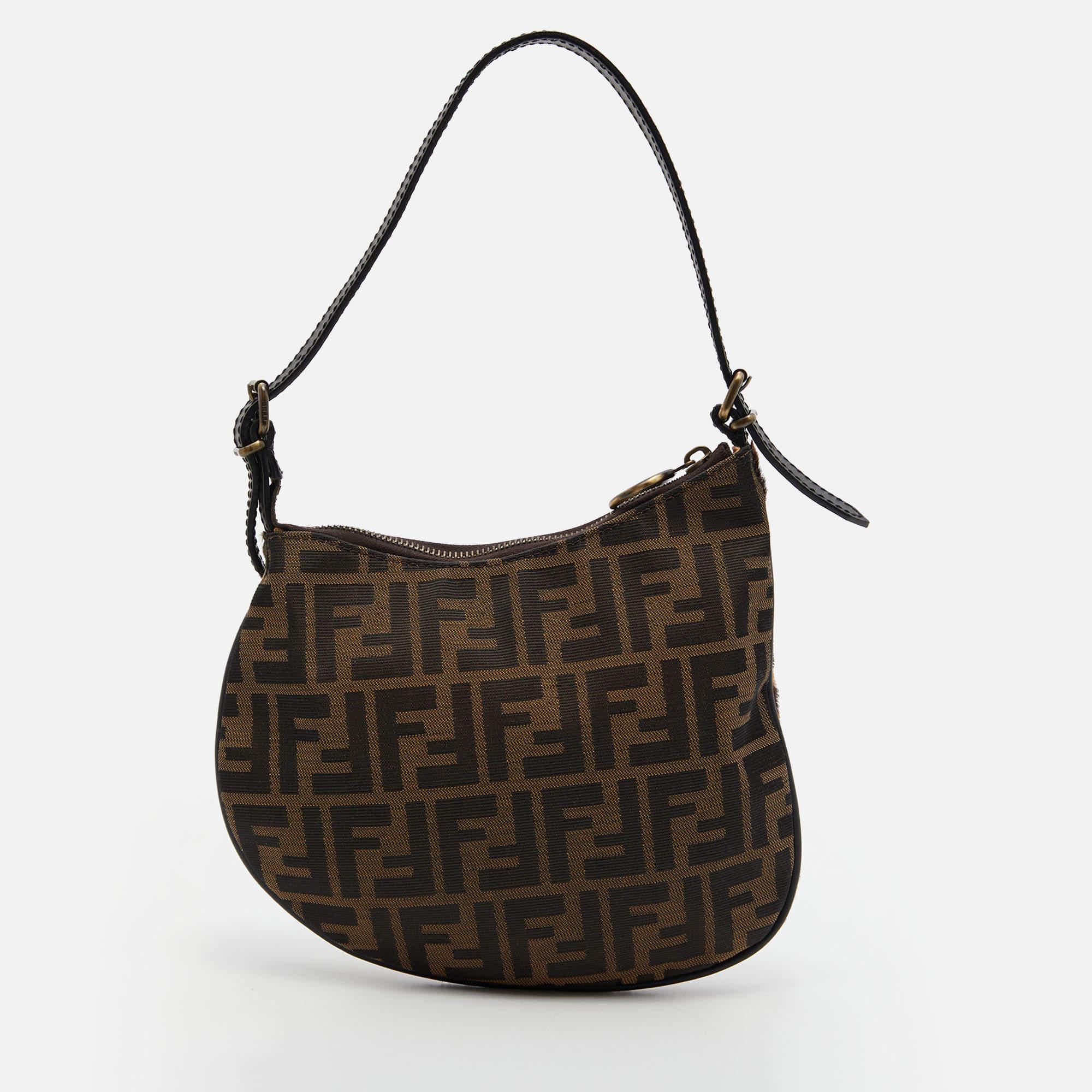 Carry a creation of wonder in your arms by choosing this Fendi Oyster bag which has been meticulously crafted from Zucca canvas and calfhair. The hobo has a distinct shape, a flat handle, and a well-sized fabric interior.

