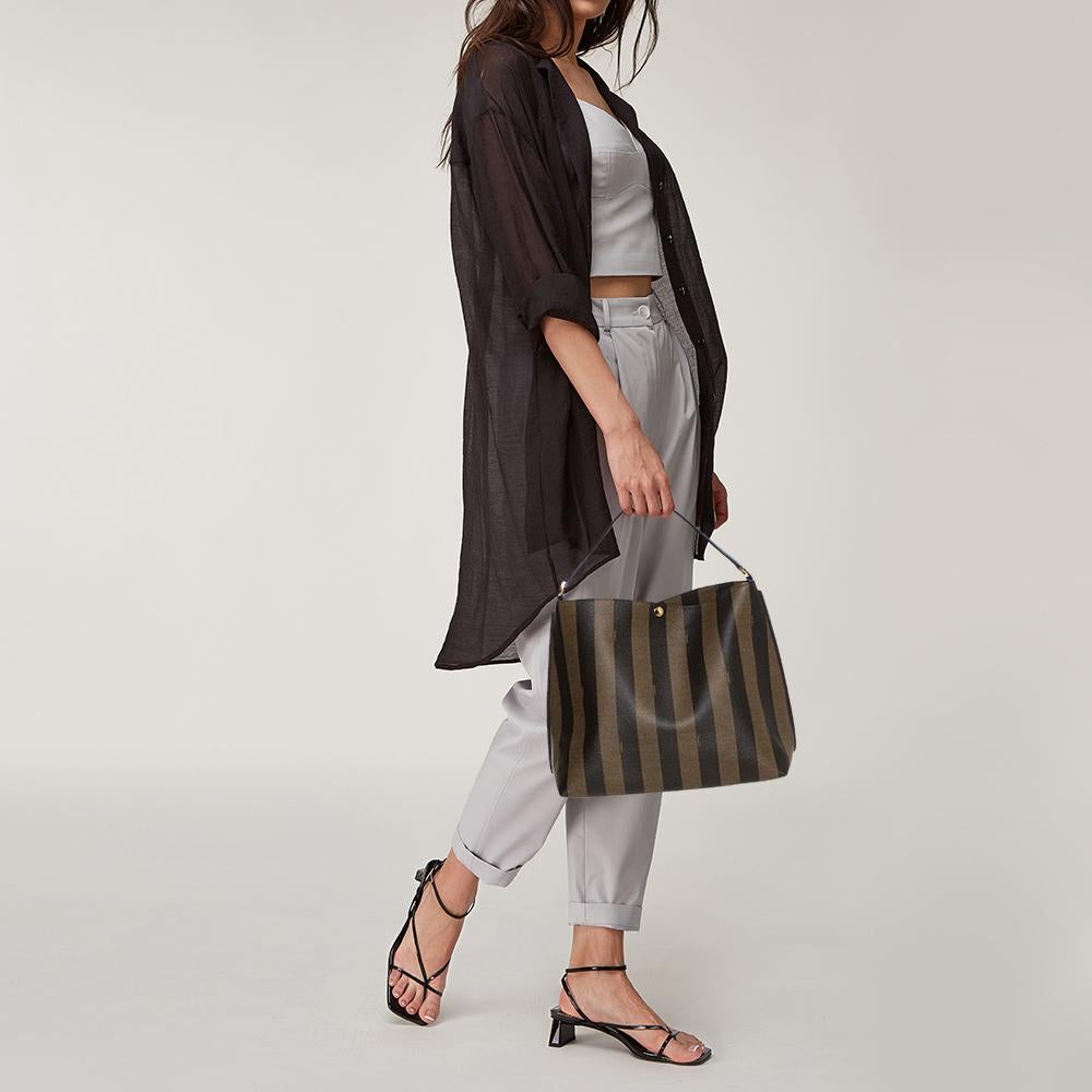 Exhibiting an up-to-date design, this hobo bag by Fendi has a sophisticated look. Crafted from tobacco coated canvas and leather and covered in pequin stripes, the bag opens to a spacious interior and is held by a single top handle. You can team