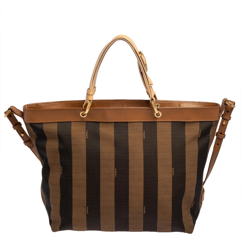 This tote by Fendi has a fashionable look. It has been made in Italy and exudes style and functionality. Crafted from pequin striped canvas and leather, the bag comes with a spacious fabric interior and it is held by twin top handles as well as a