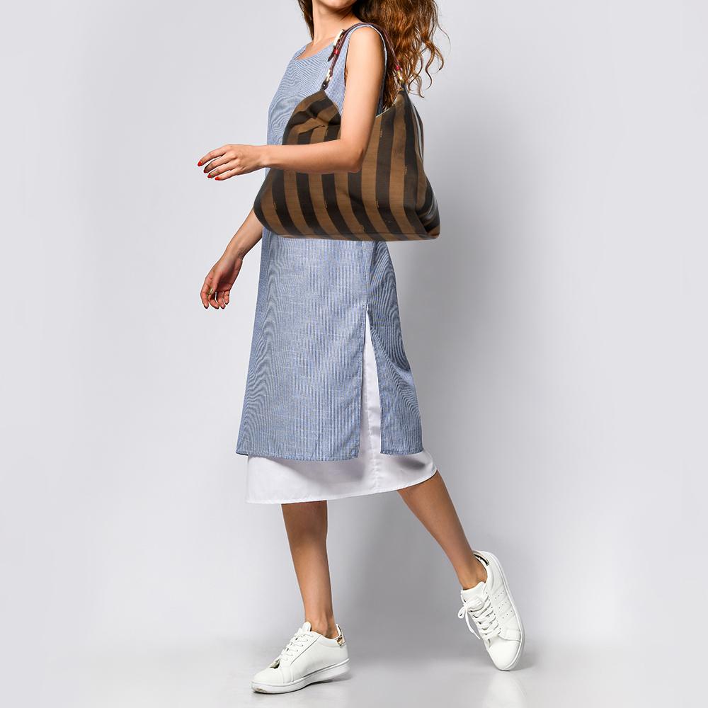This Fendi hobo is a fine choice if you're looking for an everyday bag. Crafted using signature pequin striped canvas, the bag is held by a single leather handle and detailed with gold-tone hardware. Its spacious interior is lined with suede and