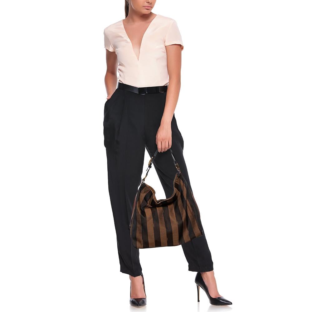 Diese Hobo von Fendi präsentiert sich in modernem Design und hat einen raffinierten Look. Die aus tabakfarbenem Canvas und Leder gefertigte Tasche mit Pequin-Streifen öffnet sich zu einem geräumigen Innenraum und wird von einem einzigen Henkel oben
