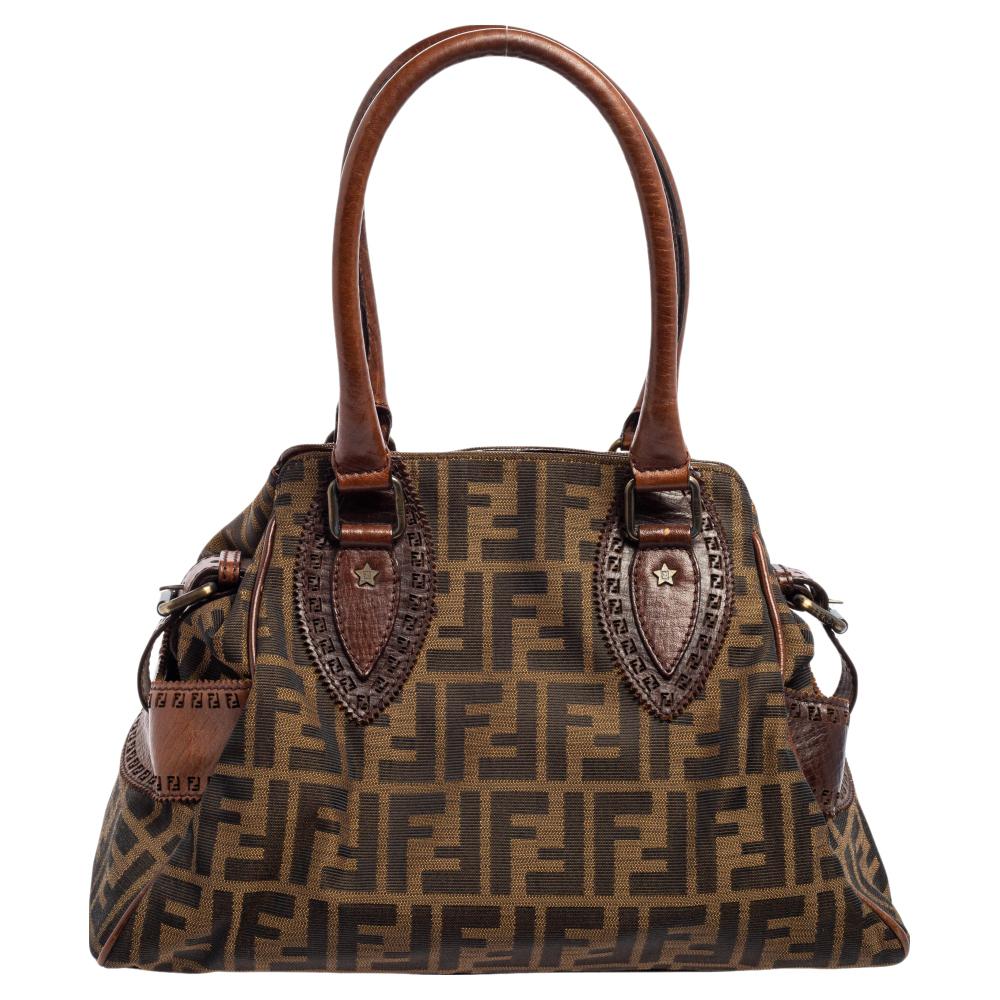 The Chef De Jour bag from the House of Fendi exhibits style and elegance in every way. It has been designed using Tobacco canvas and leather on the exterior. It comes with dual handles and has a fabric-lined interior. Look elegant as you carry this