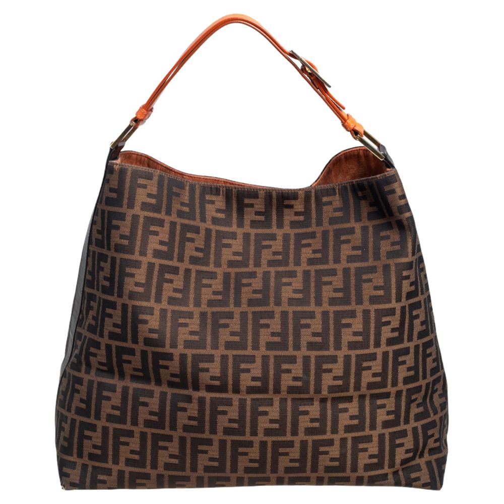 This classy and practical Fendi hobo would go perfectly well with all your outfits. Crafted from the brand's signature tobacco Zucca canvas, the bag is enhanced with leather trims. It features a single handle and opens to a fabric-lined interior