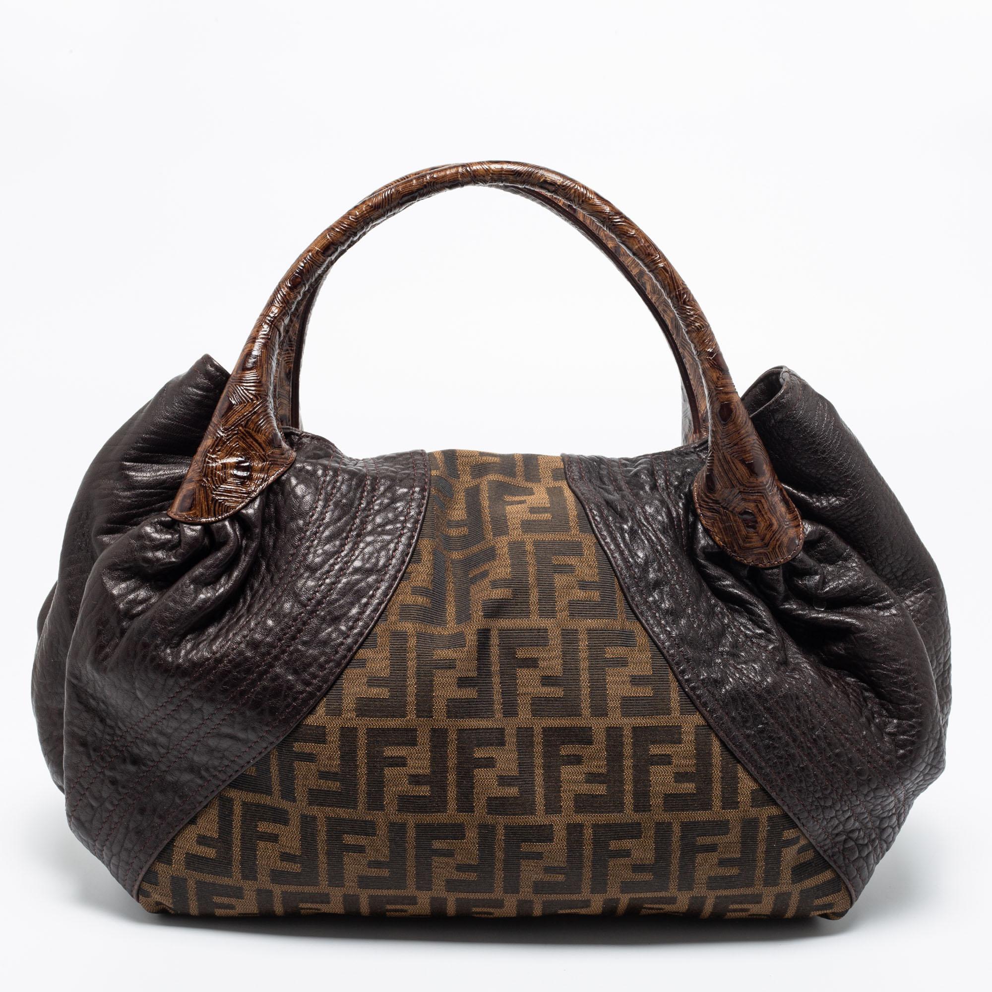 This Fendi Spy bag promises to take you through the day with ease, whether you're at work or out and about in the city. From its design to its structure, the Zucca canvas & leather bag promises charm and durability. It flaunts two woven handles and