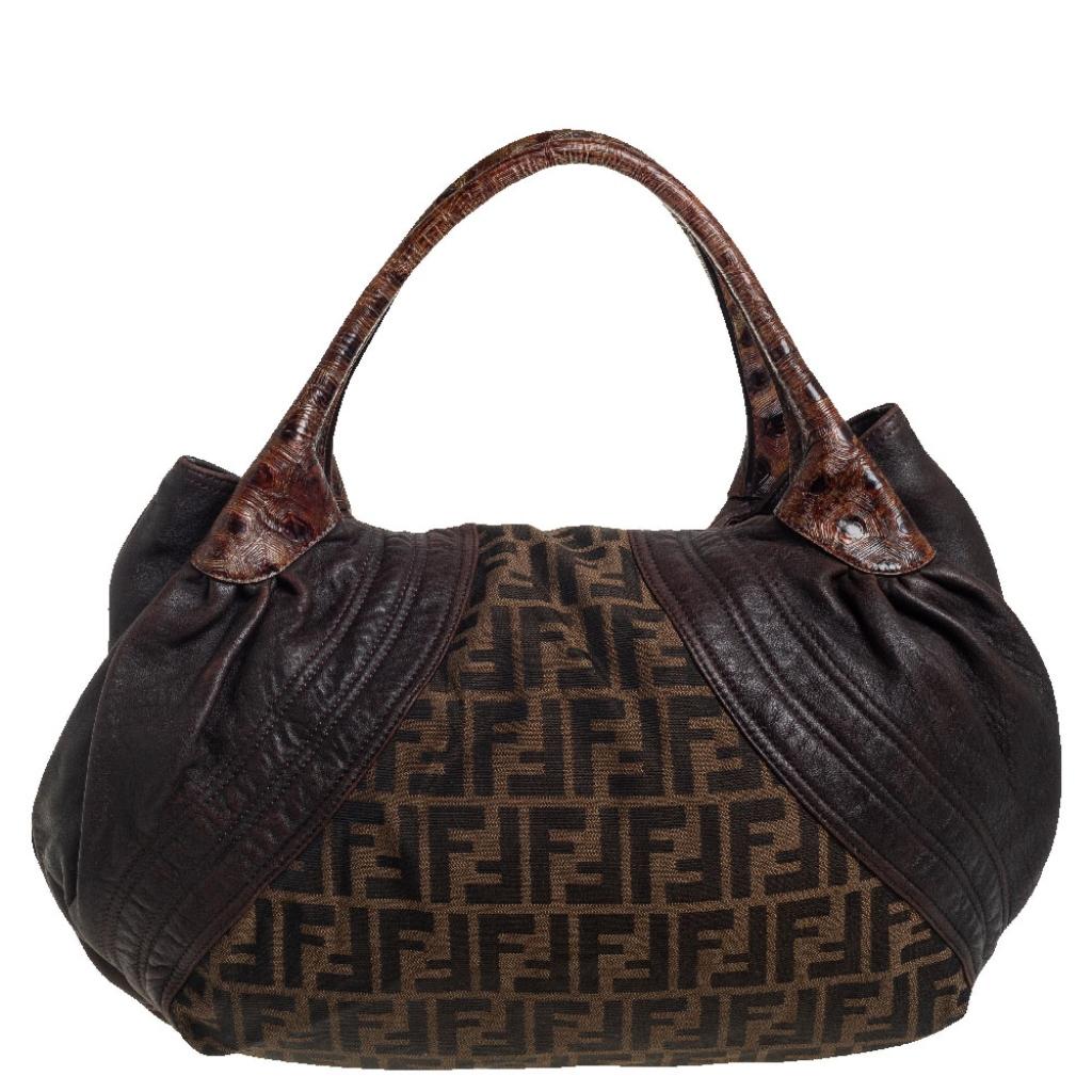 Stylish, versatile, and great for everyday use, this Fendi Spy hobo is a closet staple. Made from Zucca canvas, it is designed with panels of Tortuga leather and comes with a spacious interior. Hold it by the top handle and parade the hobo in style.
