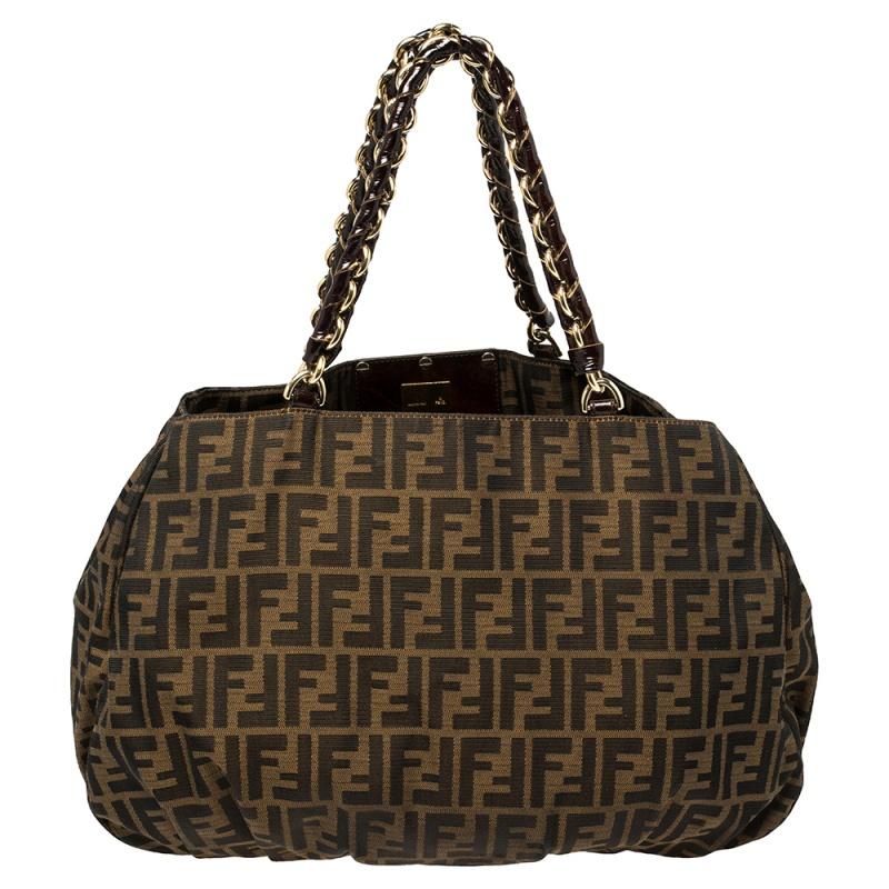 An effortlessly chic classic Fendi creation, this Zucca canvas Mia tote will definitely be your everyday bag. It features Fendi's signature Zucca canvas exterior with pleated details and is accented with a gold-tone FF logo. The top handles are
