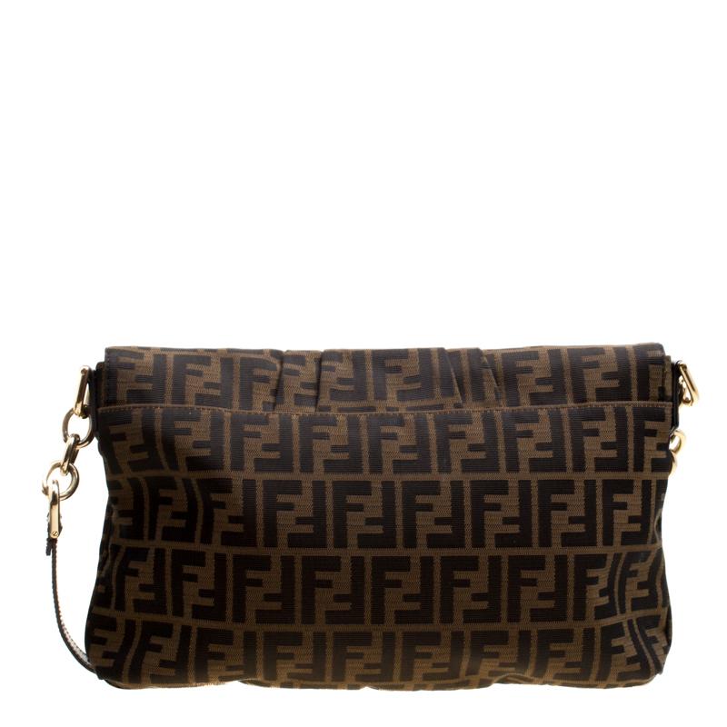 Exceptionally crafted in Italy, this Mia flap bag from the house of Fendi is a much sought after accessory. Made from Tobacco Zucca canvas, the front flap comes with a striking gold-tone F motif that reveals a spacious interior sure to fit in your