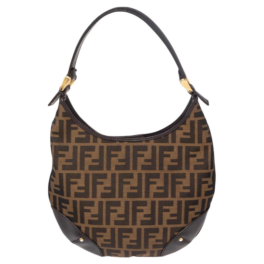 Crafted in Tobacco Zucca canvas, this Fendi bag makes a stunning addition to any modern-day edit. A canvas lining ensures your essentials are safe and a leather handle on top provides easy carrying options.

Includes: Original Dustbag
