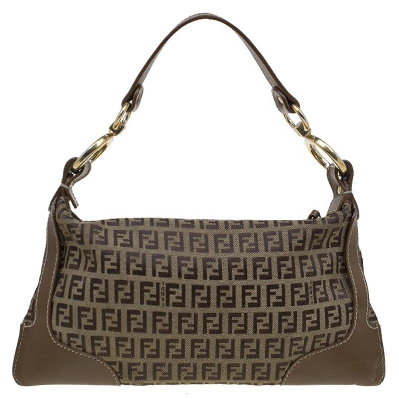 Fendi's shoulder bag is a smart alternative to your everyday tote. It is designed in a tobacco Zucchino canvas and detailed with leather trimmed edges. It comes with a top flat handle and secured with a zip closure. An exterior zip pocket helps to