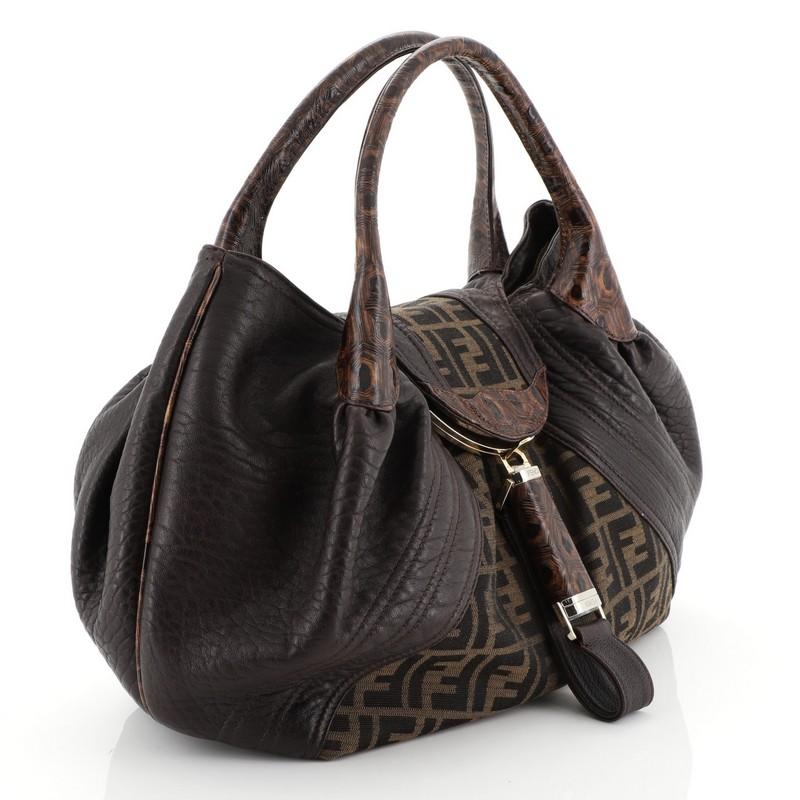 This Fendi Tortoise Spy Bag Zucca Canvas and Leather, crafted from brown zucca canvas and leather, features dual rolled genuine tortoise skin handles, pleated silhouette, 