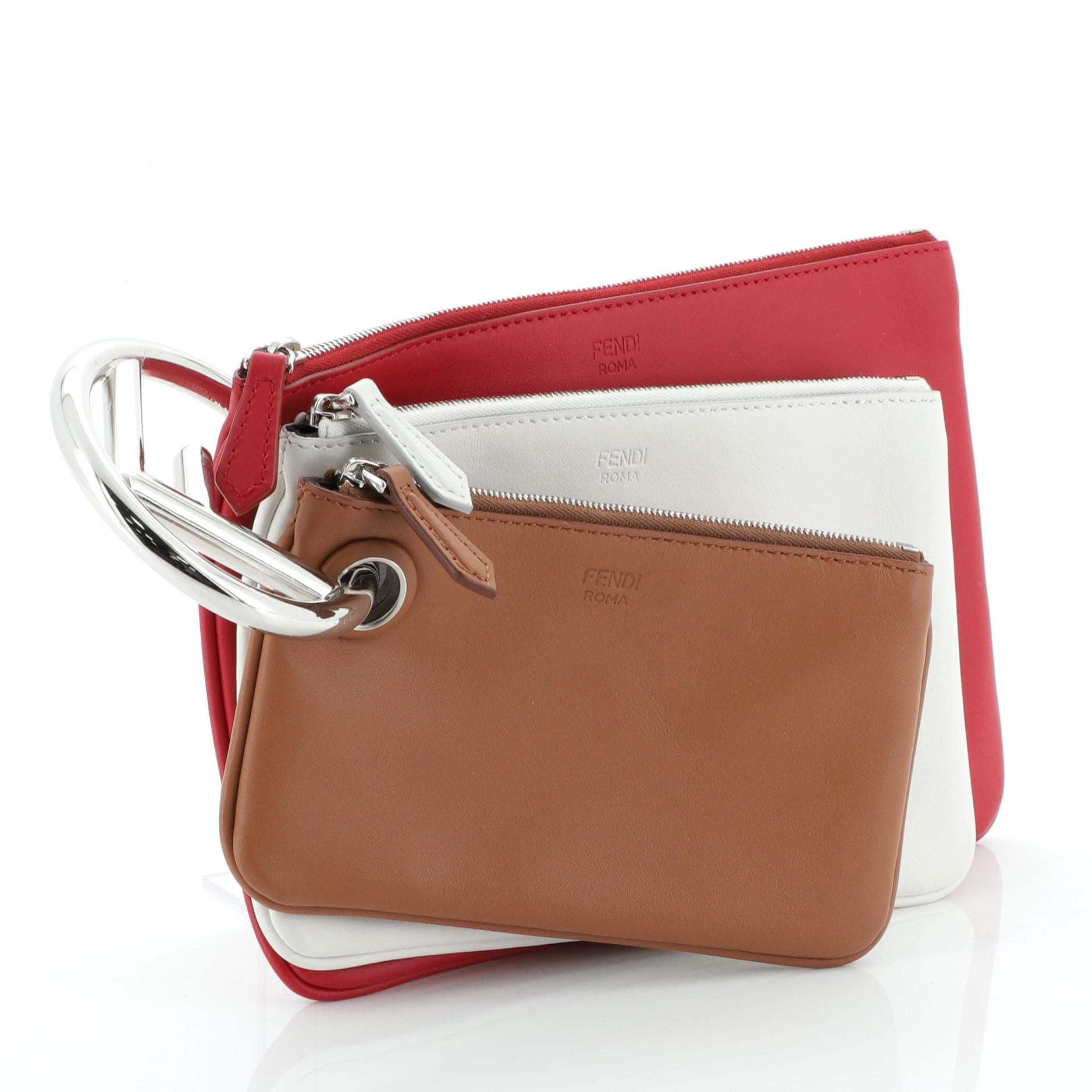 This Fendi Triplette Pouch Set Calfskin, crafted in red and multicolour calfskin leather, features a small, medium and large pouch, Fendi logo handle and silver-tone hardware. Its zip closure opens to a brown fabric interior. 

Estimated Retail