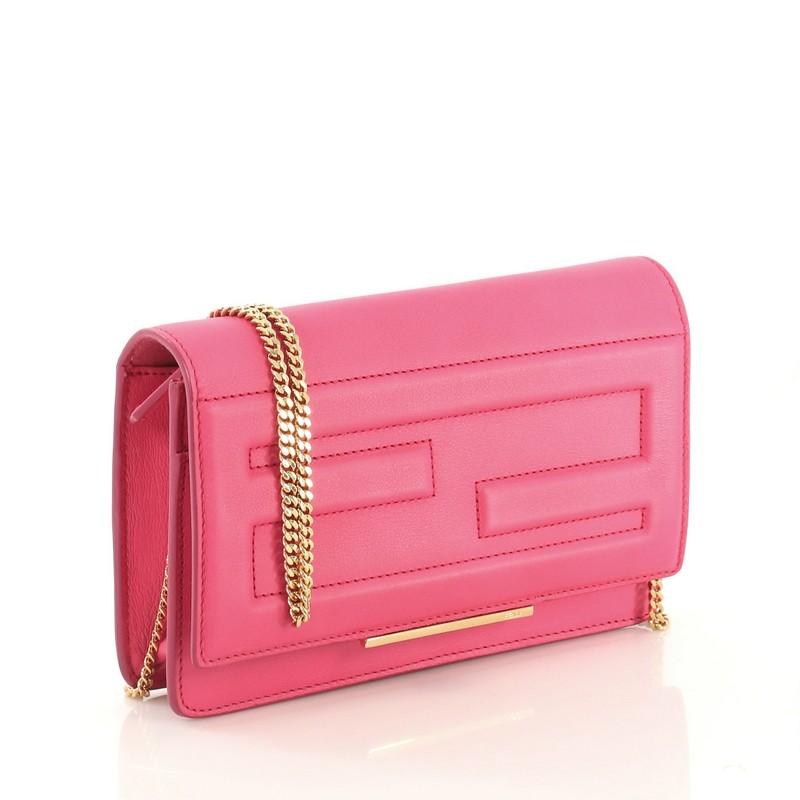 This Fendi Tube Wallet On Chain Leather, crafted in pink leather, features a chain-link shoulder strap, two large embossed Fendi F's on the flap and gold-tone hardware. Its snap closure opens to a pink leather and fabric interior with multiple card