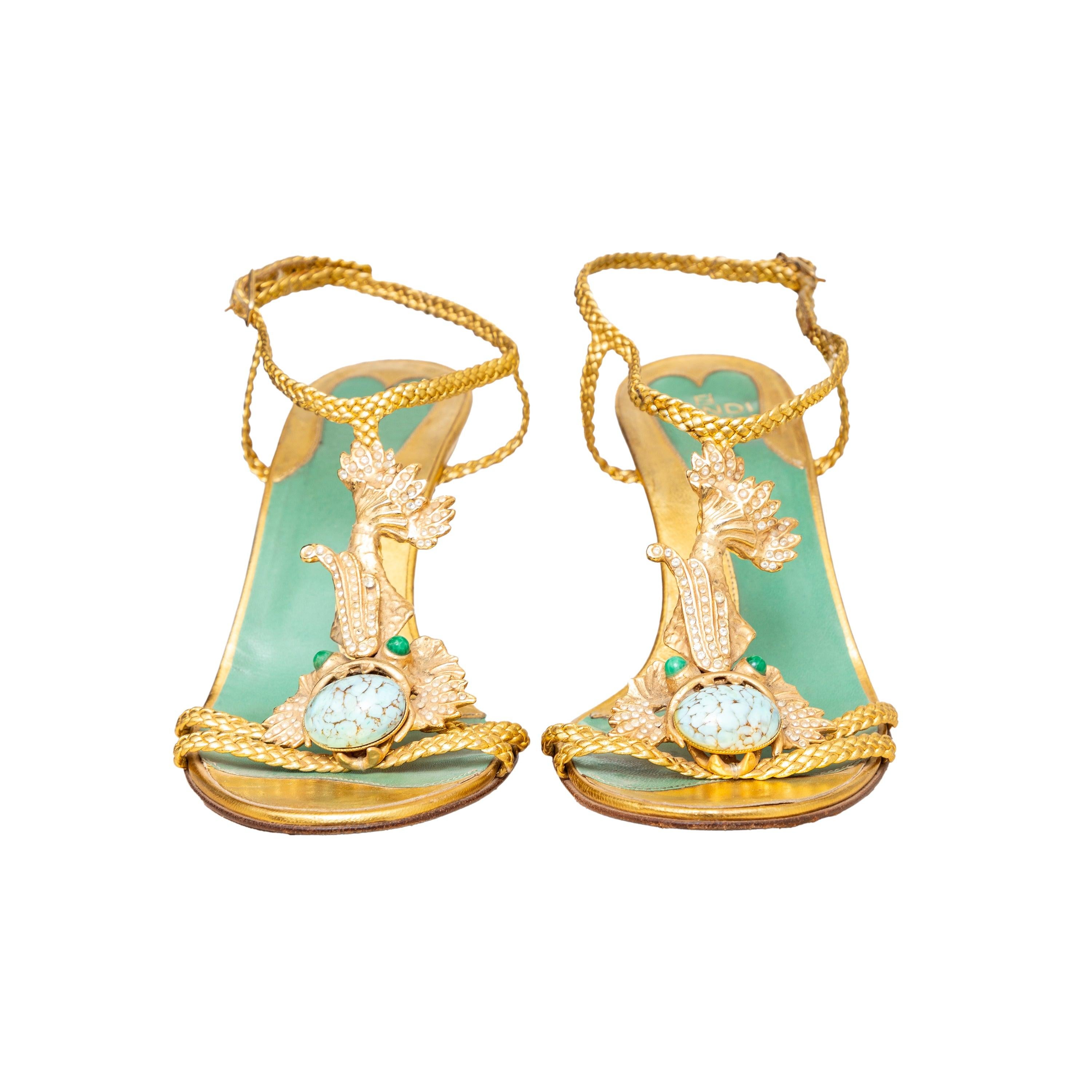 Estos raros zapatos de tacón Fendi con pedrería turquesa de los años 90 presentan una exquisita piel trenzada dorada con adornos de cristal y una piedra turquesa natural. Perfectos para la noche, estos tacones vintage presentan un delicado