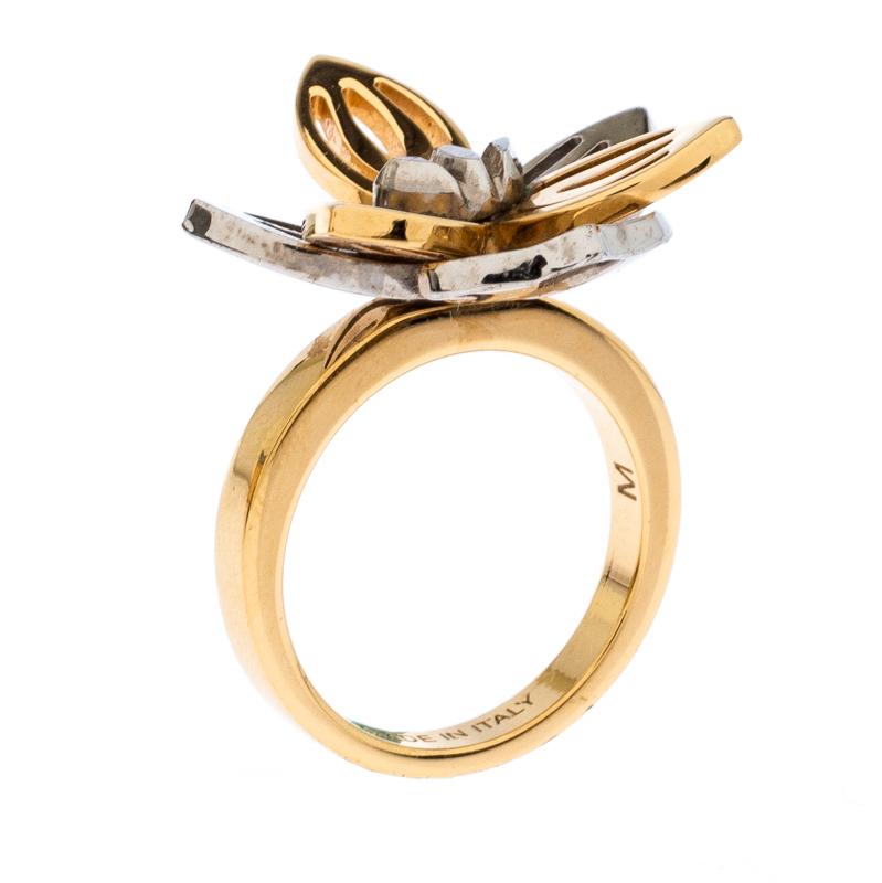 This beautiful ring from Fendi is ideal for everyday wear. It has a beautiful flower head cast from two-tone metal. The outer petals have a lovely silver-tone which contrasts well with the inner gold-tone petals. The creation is accented with logo