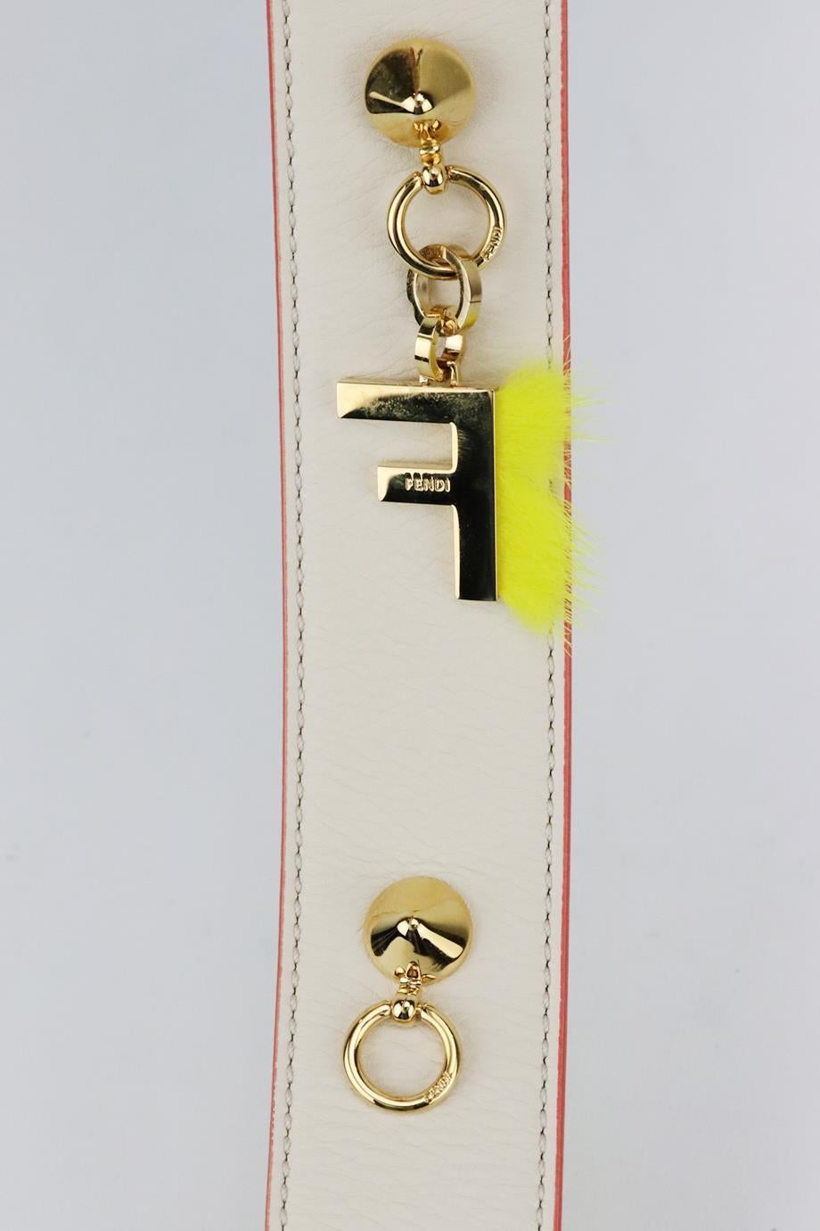 Fendi two tone leather bag strap with charm. Made from ecru, navy and yellow leather with red and blue trim and gold-tone clasps, it also comes with a detachable 'F' charm. L: 44 in. W: 1.5 in