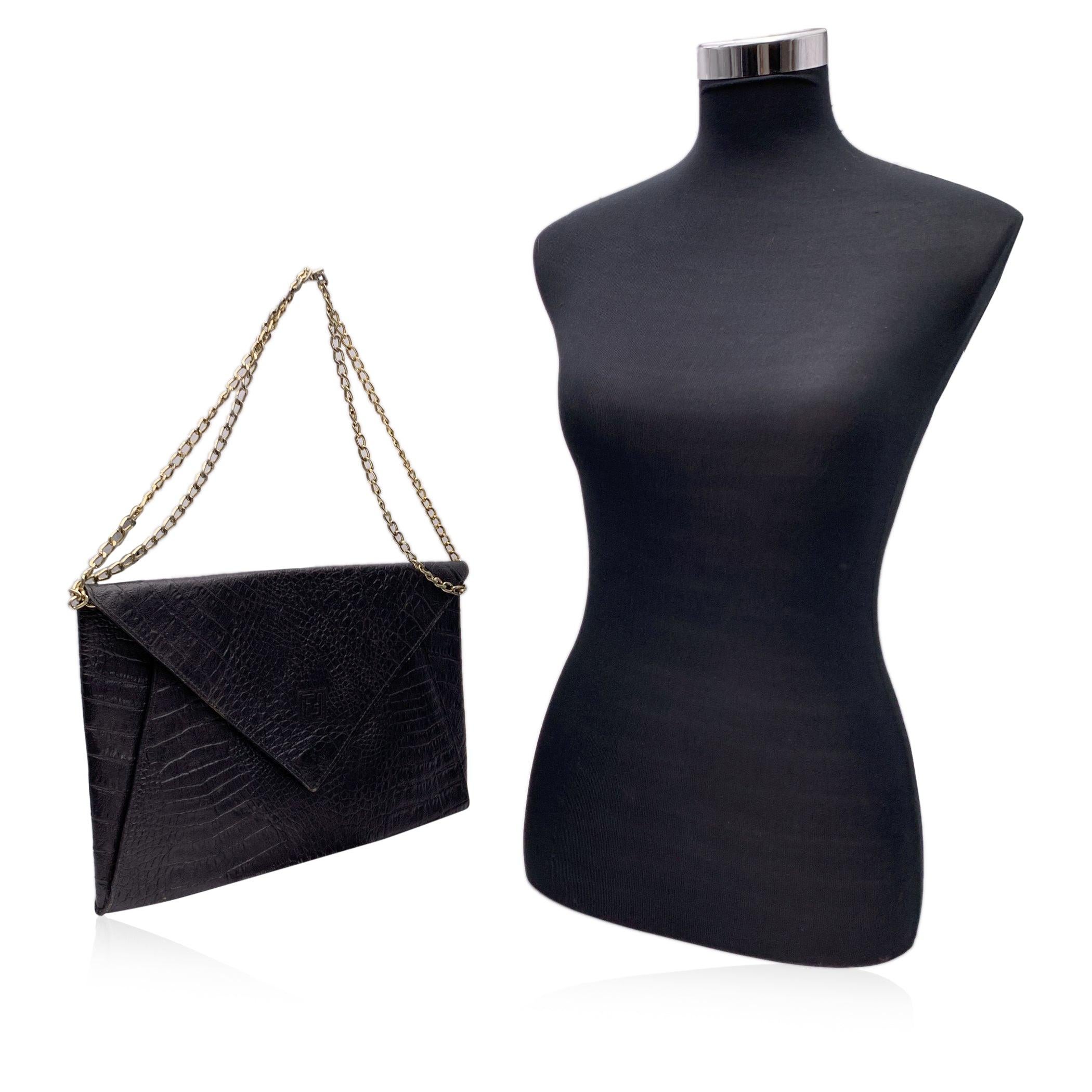 Vintage FENDI Porfolio/clutch bag from the 80s. Crafted in black leather with embossed crocodile look. Flap with magnetic button closure. FF - Fendi logo on the front, Signature fabric lining. 1 side zip pocket inside. Chain shoulder strap. 'Fendi