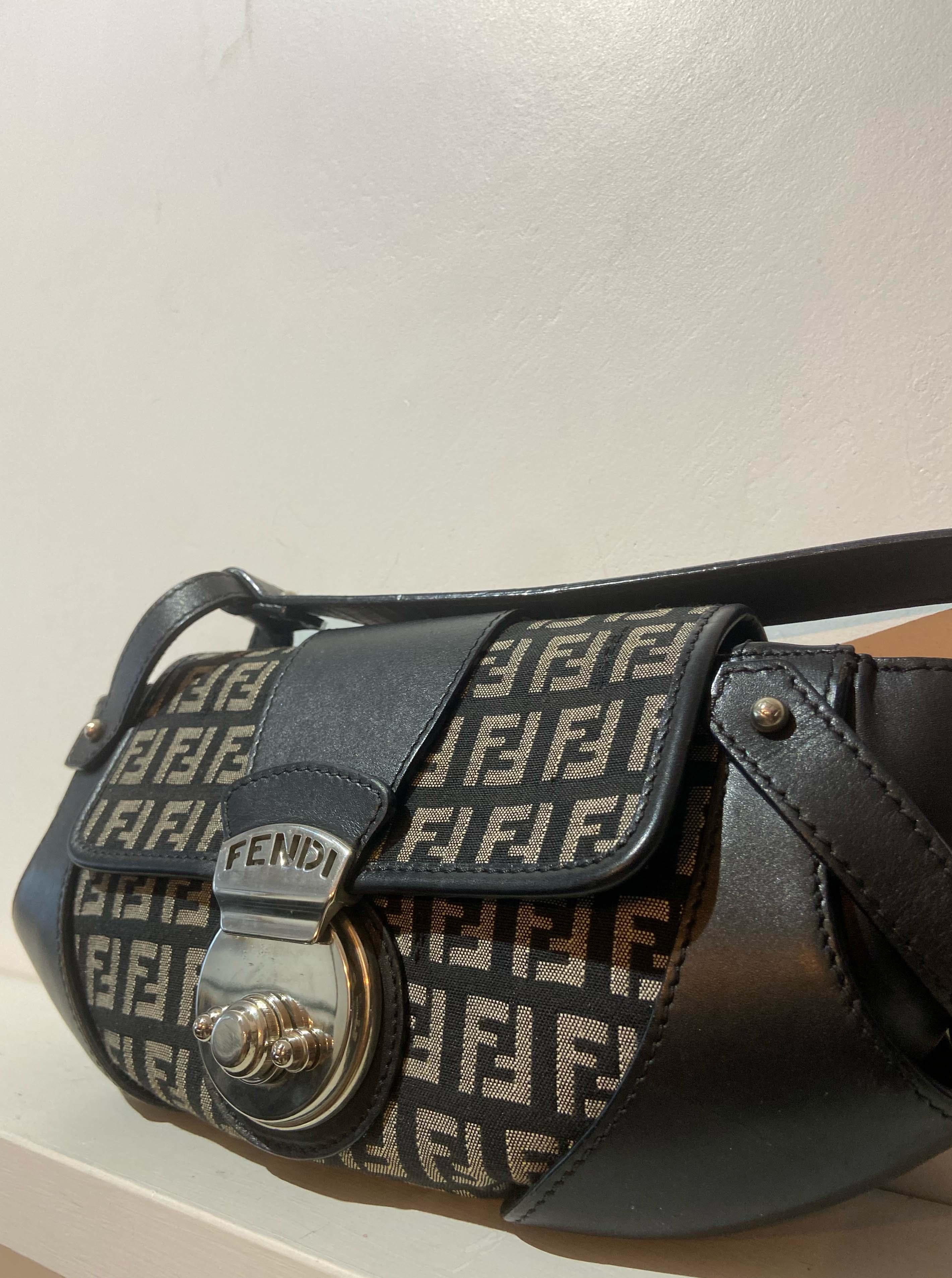 Vintage Fendi 1990’s Mini croissant shape shoulder bag.  Features navy zucca print monogram canvas, navy leather straps and back interior pocket. Fendi silver hardware and front padlock closure. In excellent vintage condition. 

Brand: Fendi
Colour: