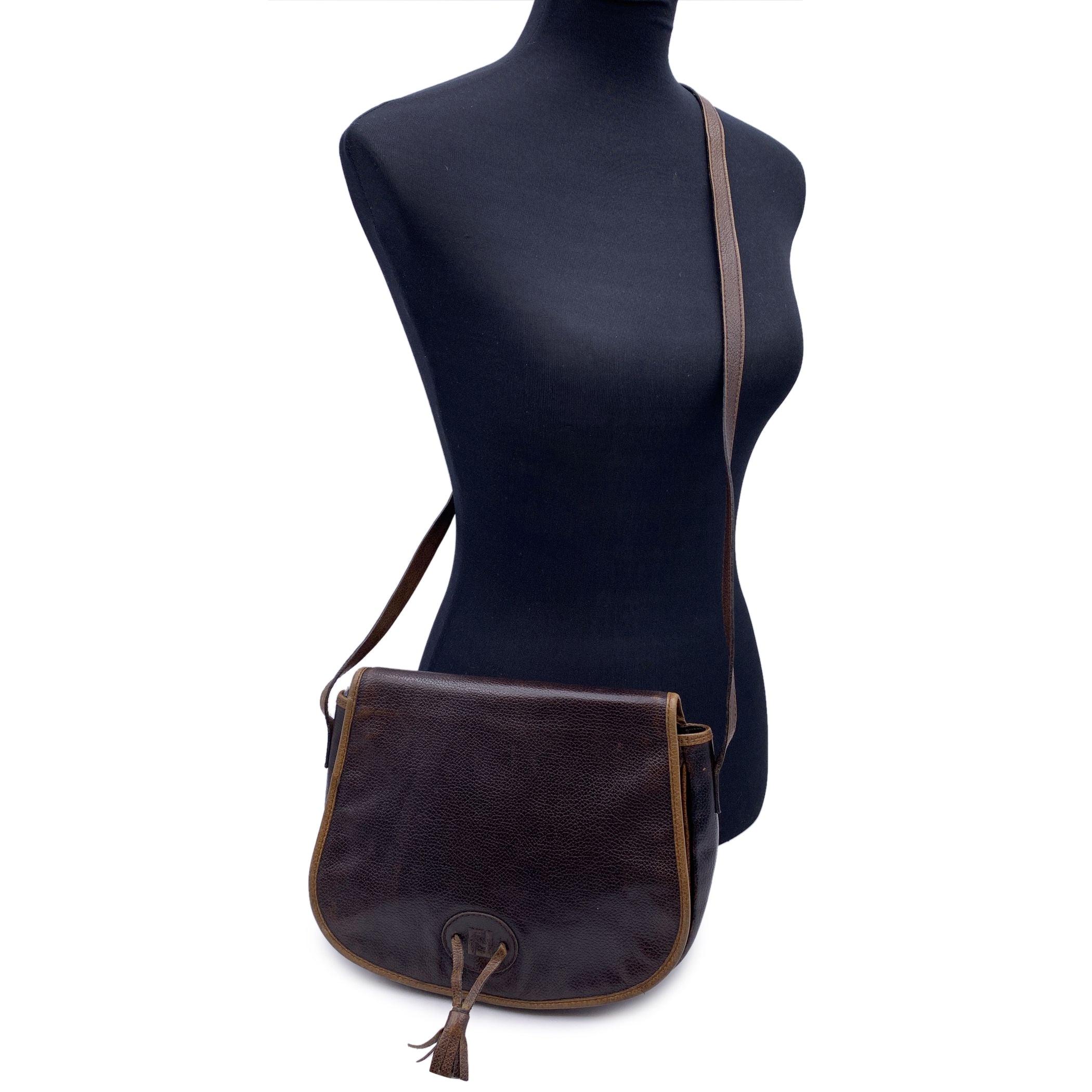 Fendi Vintage Shoulder bag. Dark brown leather and tan leather. Flap with magnetic butttons closure. FF - Fendi logo and tassels on the front. Brown leather lining. 1 side zip pocket inside. Adjustable shoulder strap. 'FENDI s.a.s. Roma - Made in