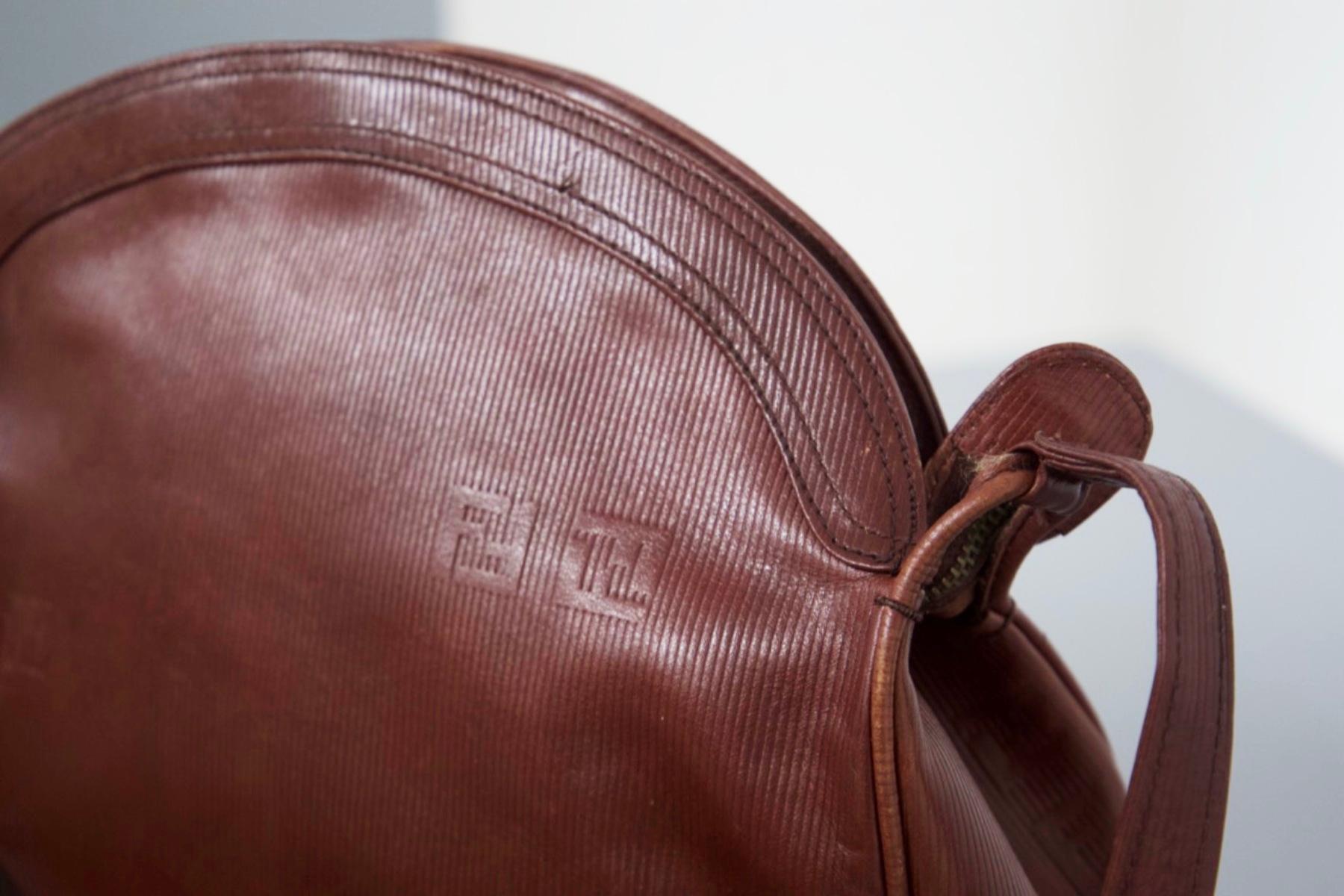 Vintage-Tasche aus braunem Leder, entworfen von Fendi in den 1980er Jahren, hergestellt in Italien.
Die Tasche ist ganz aus braunem Leder und hat eine ovale Form auf der Oberseite mit einem Reißverschluss, mit dem sie geöffnet und geschlossen werden