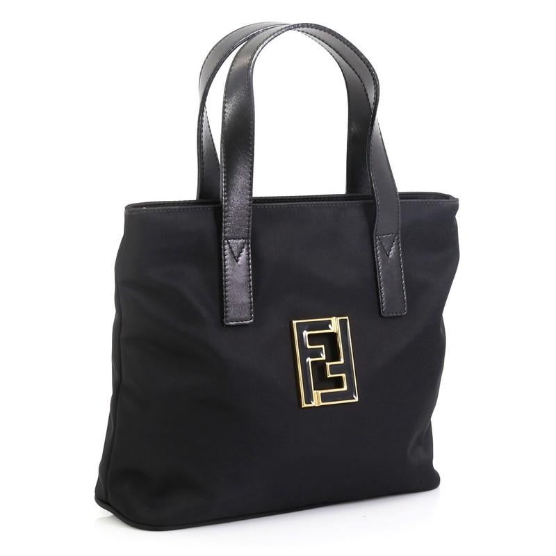 This Fendi Vintage Convertible Tote Nylon Mini, crafted from black nylon, features flat leather handles and gold-tone hardware. It opens to a black fabric interior. 

Condition: Great. Minimal wear on exterior, creasing on handles, scratches on
