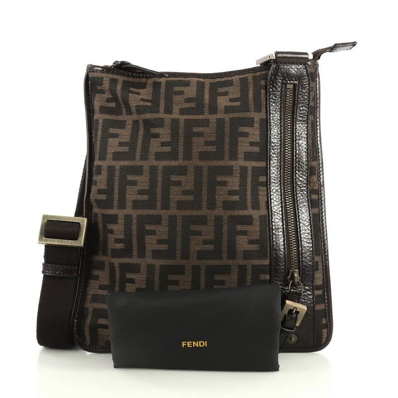 This Fendi Vintage Flat Crossbody Bag Zucca Canvas, crafted from brown zucca canvas, features an adjustable strap, front zip pocket, and aged gold-tone hardware. Its top zip closure opens to a brown fabric interior. 

Estimated Retail Price: