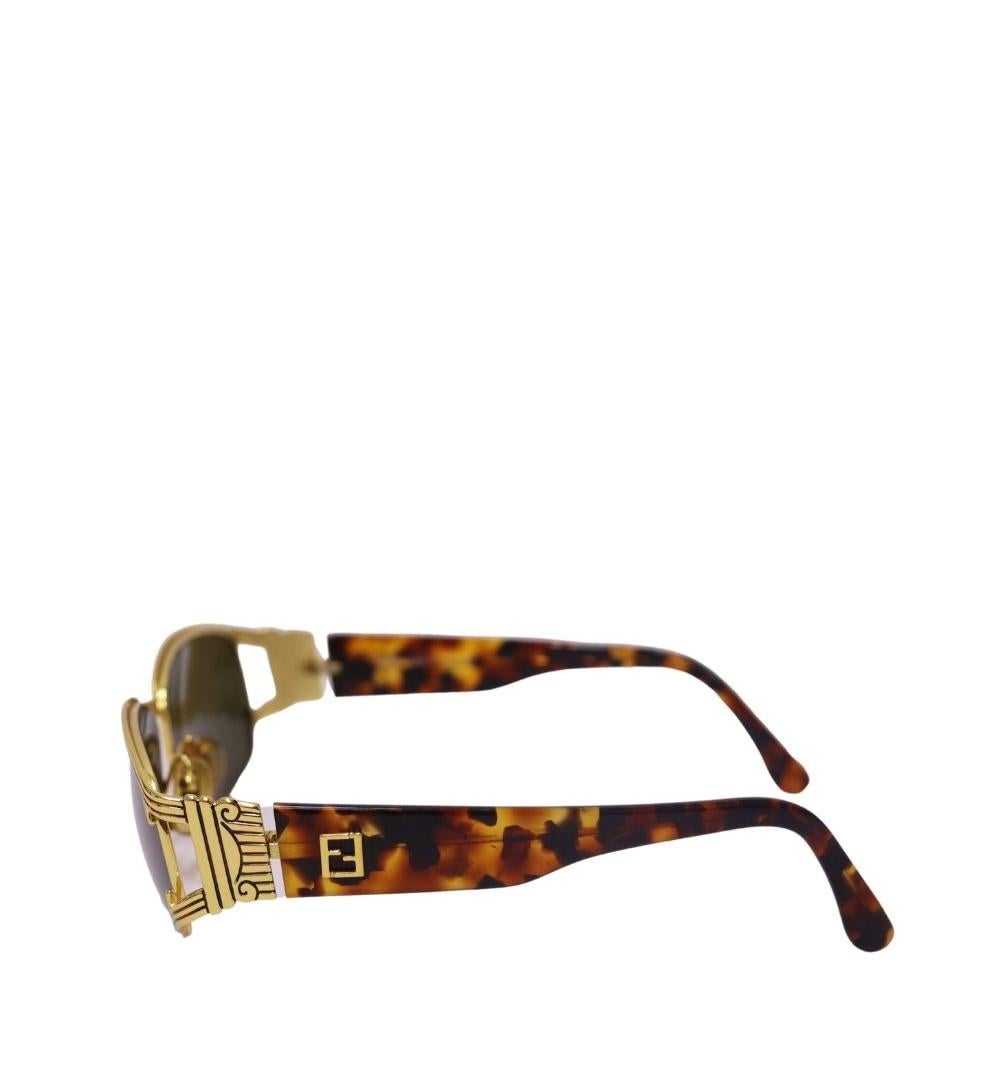 Fendi Vintage Gold Sunglasses, Featuring tortoise large frame, solid grey (UV protection) lenses and FF logo integrated in temples.

Hardware: Acetate
Lens: Black
Lens Width: 60 mm
Lens Bridge: 15 mm
Arm Length: 130mm
Overall Condition: