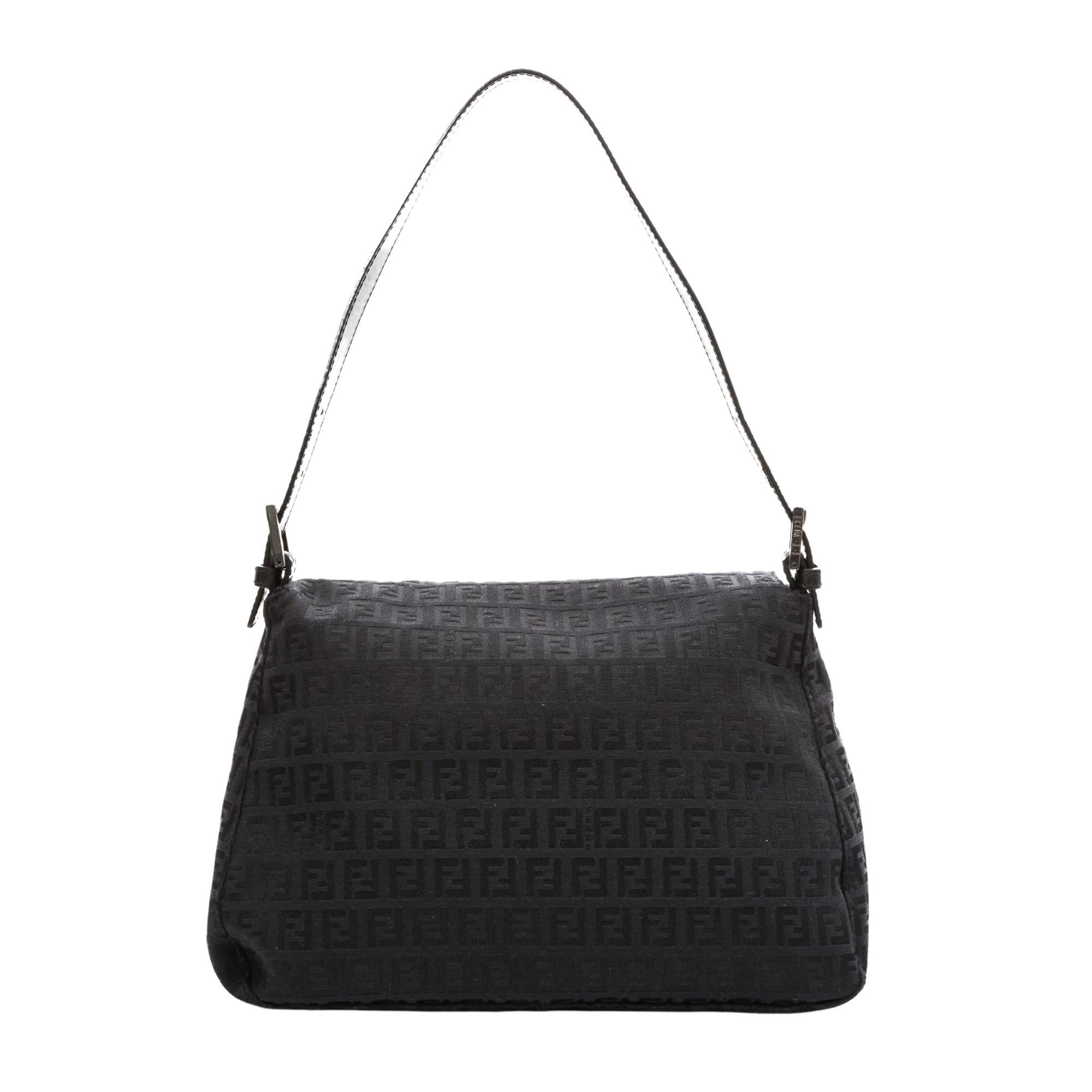 This Mama baguette is made with black canvas with black Fendi Zuccino embossing throughout. The bag features an adjustable looping leather strap, gunmetal buckle links for the top strap and a front leather strap with a gunmetal FF logo. This flap