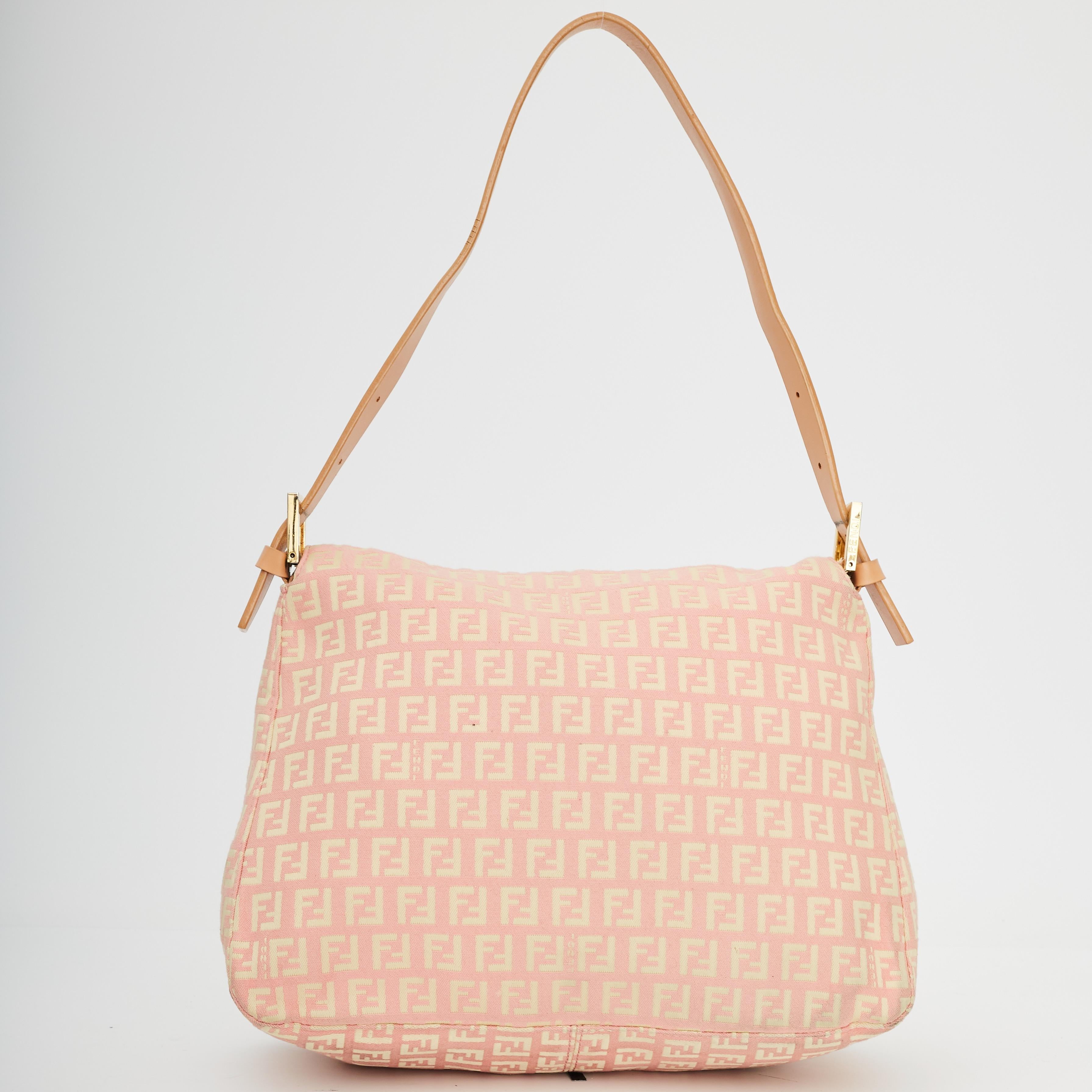 This Mama baguette is made with pink canvas with Fendi Zuccino jacquard throughout. The bag features an adjustable flat leather shoulder strap with polished silver links, a front leather strap with a polished silver FF logo buckle, flap closure with