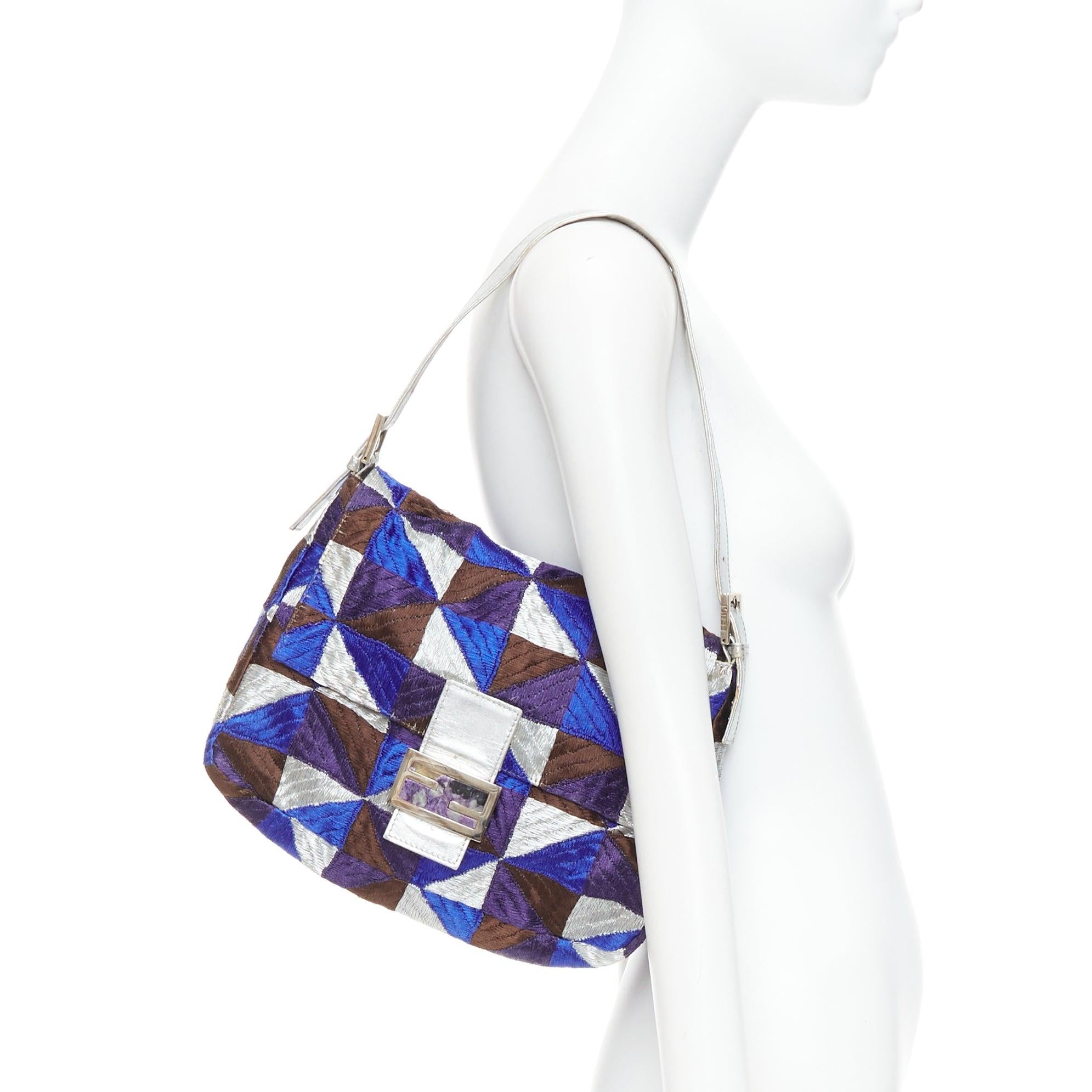 FENDI Vintage Mamma Baguette Umhängetasche aus blauem, silbernem und lila Stoff
Referenz: TGAS/E00709
Marke: Fendi
Modell: M amma Baguette
MATERIAL: Stoff, Leder
Farbe: Silber, Violett
Muster: Geometrisch
Verschluss: Magnet
Innenfutter: Lila