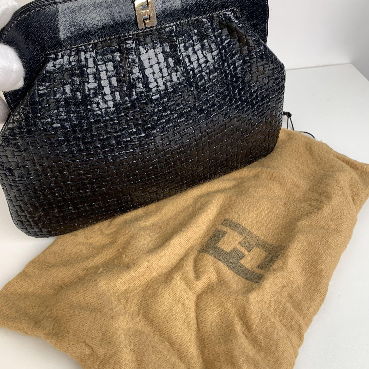 Fendi Vintage Navy Blue Woven Leather Clutch Bag. Navy Blue woven leather. FF - FENDI metal logo on the front. 'FENDI - Roma - Made in Italy'embossed inside. Framed top with button closure. Blue lining. 1 side zip pocket