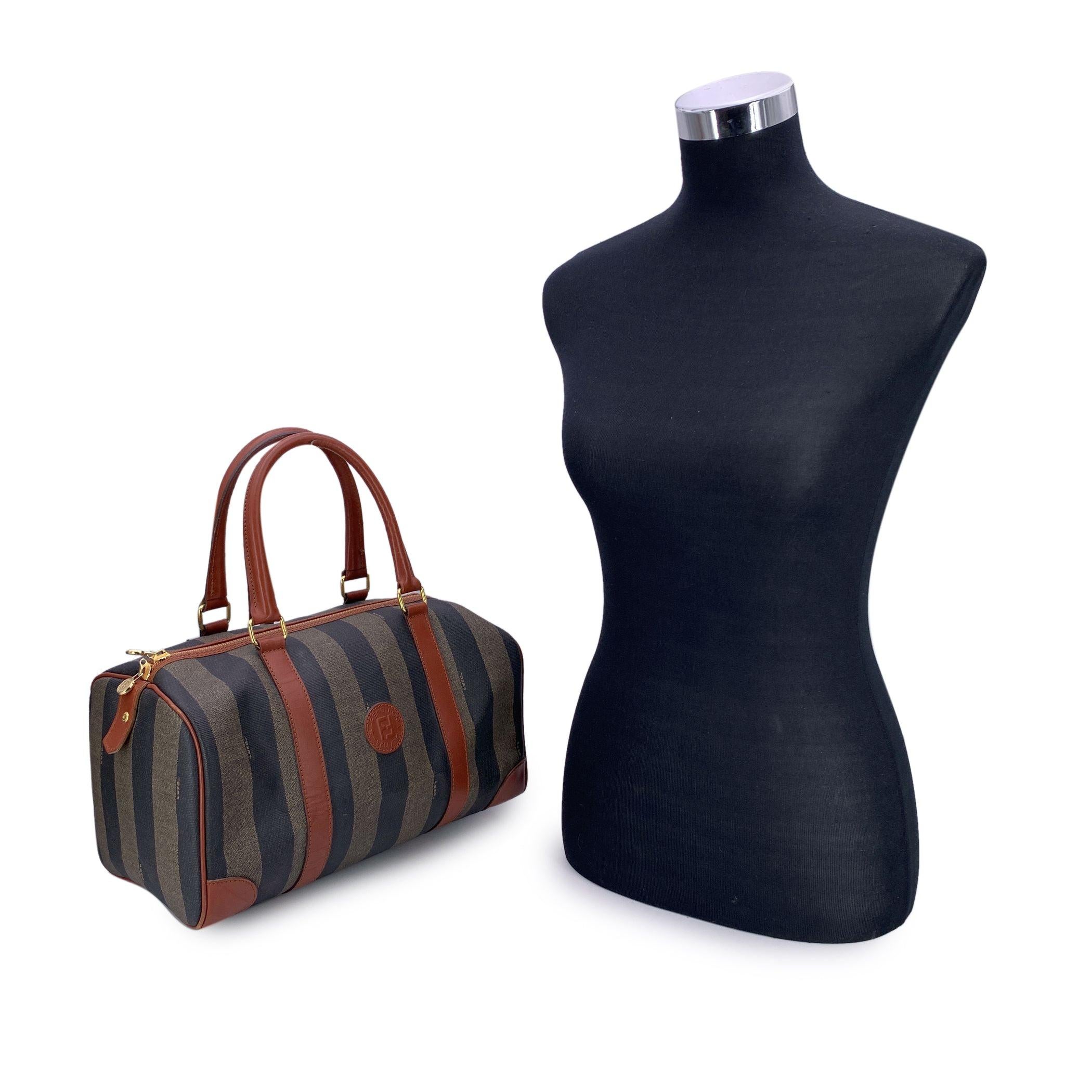 Step into the world of iconic Italian craftsmanship with the Fendi Vintage Pequin Striped Canvas Boston Bag. A perfect fusion of bold design and timeless luxury, this piece features the signature Pequin striped canvas, a striking pattern that has