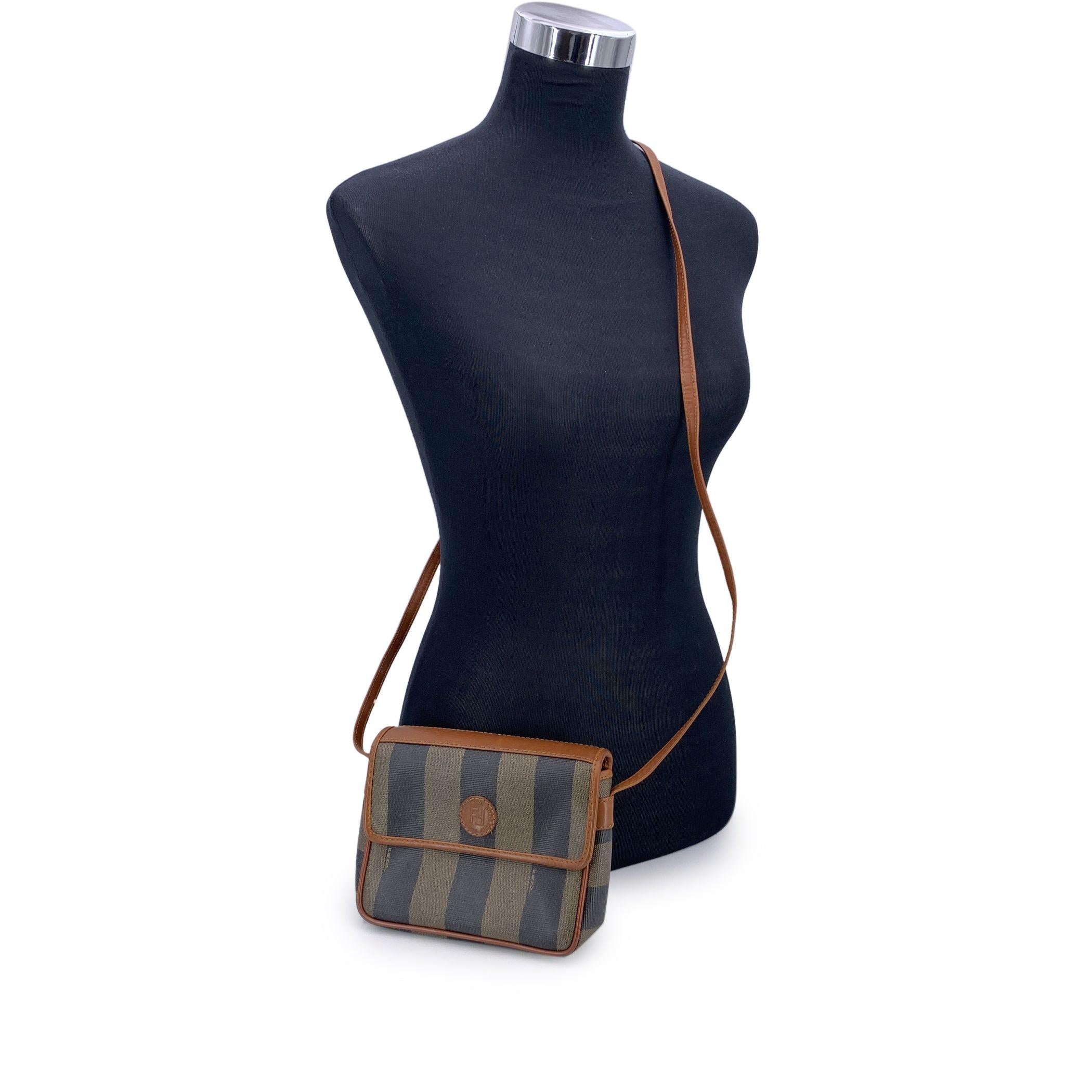 Step into a world of timeless Italian design with this vintage Fendi Pequin Striped Canvas Small Crossbody Bag, a chic accessory that perfectly balances style and functionality. The iconic striped pequin canvas, with its bold alternating tones, is
