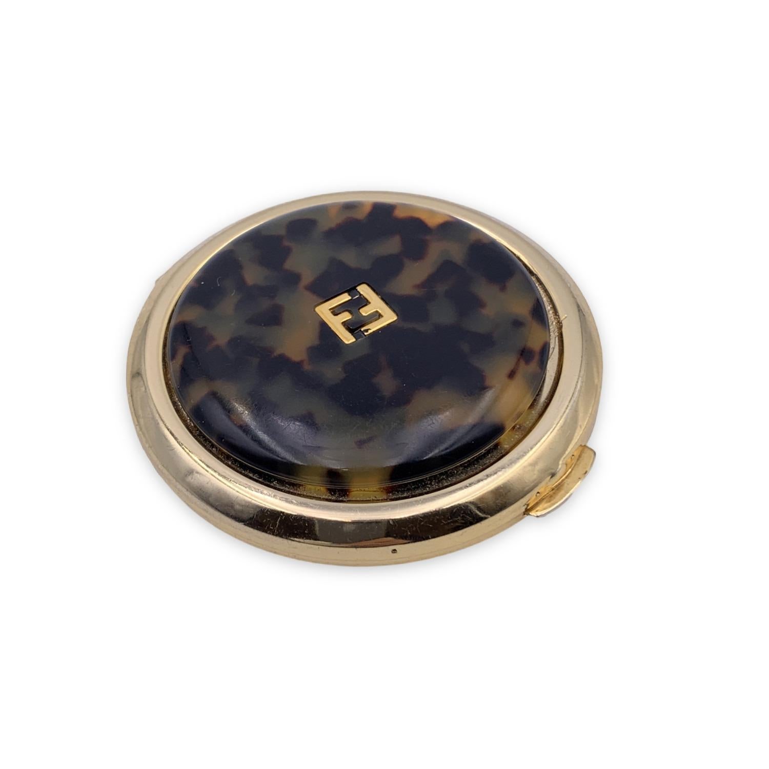 Vintage FENDI round compact mirrored Pocket Mirror in gold metal with havana lid. FF - FENDI logo on top. Snap closure. Measurements: Diameter: 3 inches - 7.6 cm.

Details

MATERIAL: Metal

COLOR: Gold

MODEL: -

GENDER: Women

COUNTRY OF