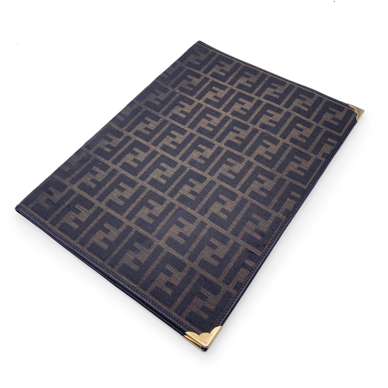 Vintage Agenda/Notebook cover by FENDI crafted in monogram Zucca canvas. Gold metal corners. Black leather interior. 'Fendi s.a.s. Roma - Made in Italy' embossed inside Details MATERIAL: Cloth COLOR: Brown MODEL: n.a. GENDER: Unisex Adults COUNTRY