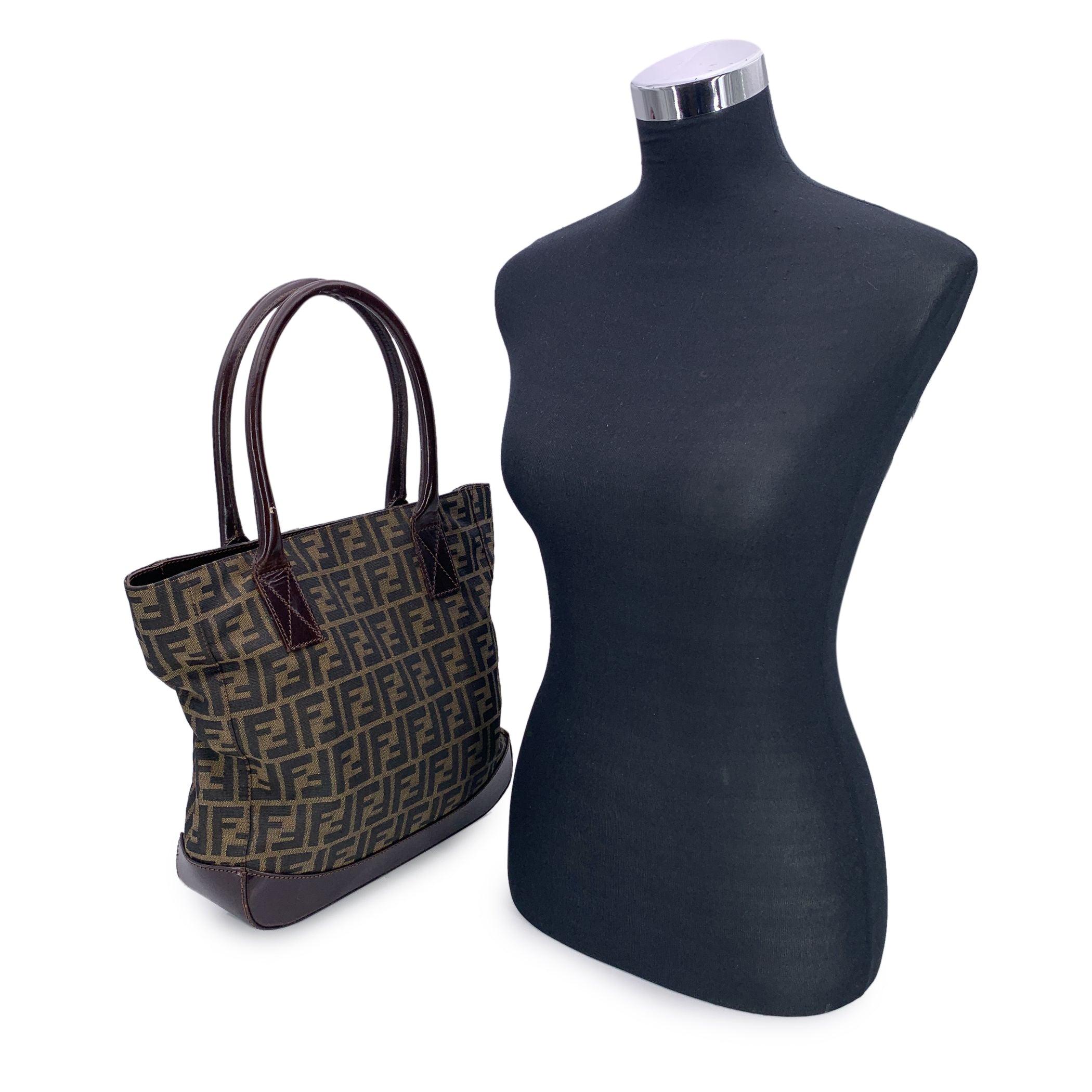 Step into the timeless elegance of Italian fashion with this stunning Fendi Zucca tote bag in the classic tobacco colorway. A true emblem of the house's heritage, the bag is crafted in the iconic FF monogram Zucca canvas-a pattern designed by Karl