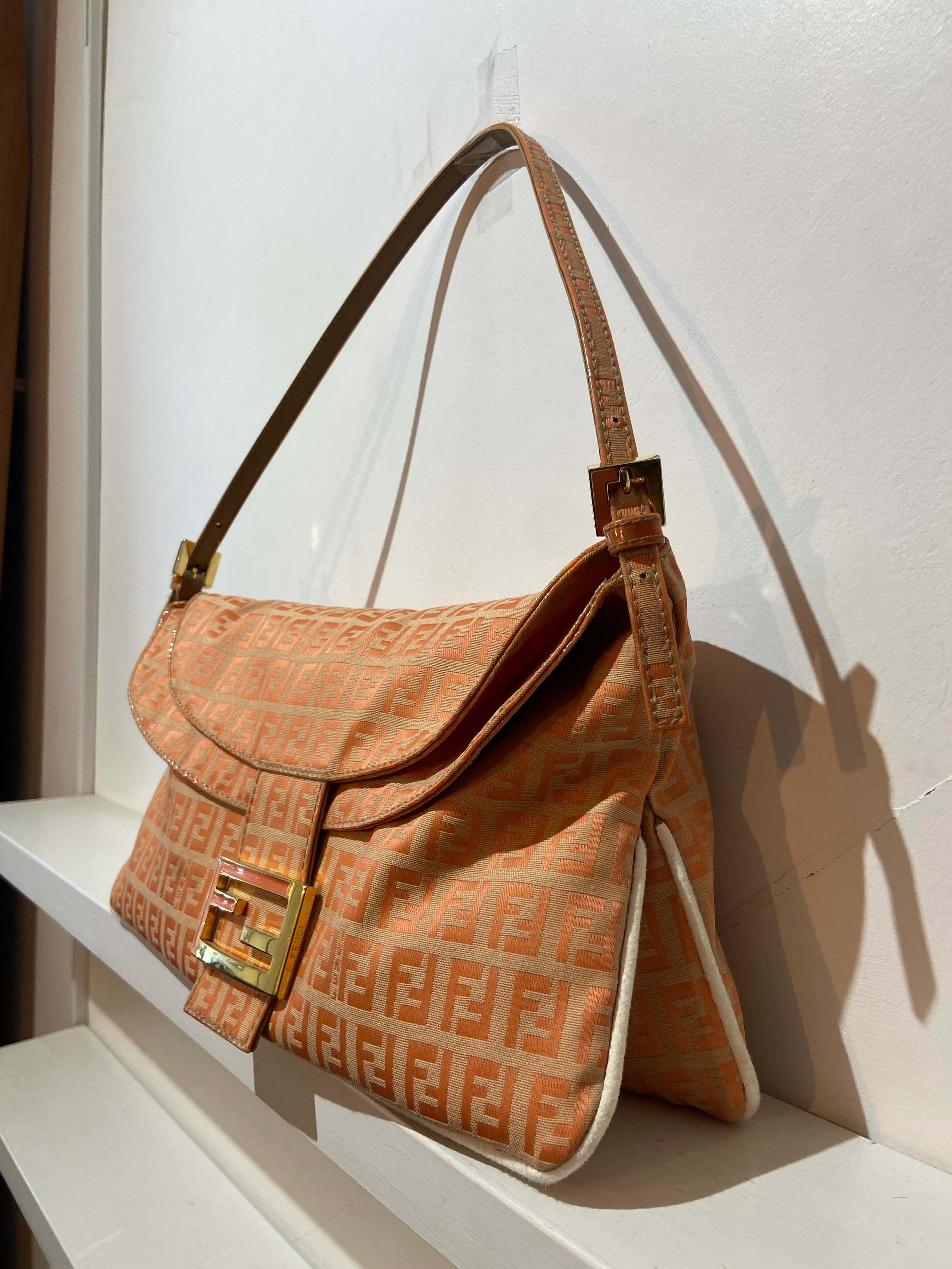 Vintage late 1990’s Fendi Mamma baguette bag .Features the signature monogram print all over all over. Iconic Fendi gold &pink front logo hardware with magnetic closure, buckles and beige satin lining with a zip inner back pocket. In excellent
