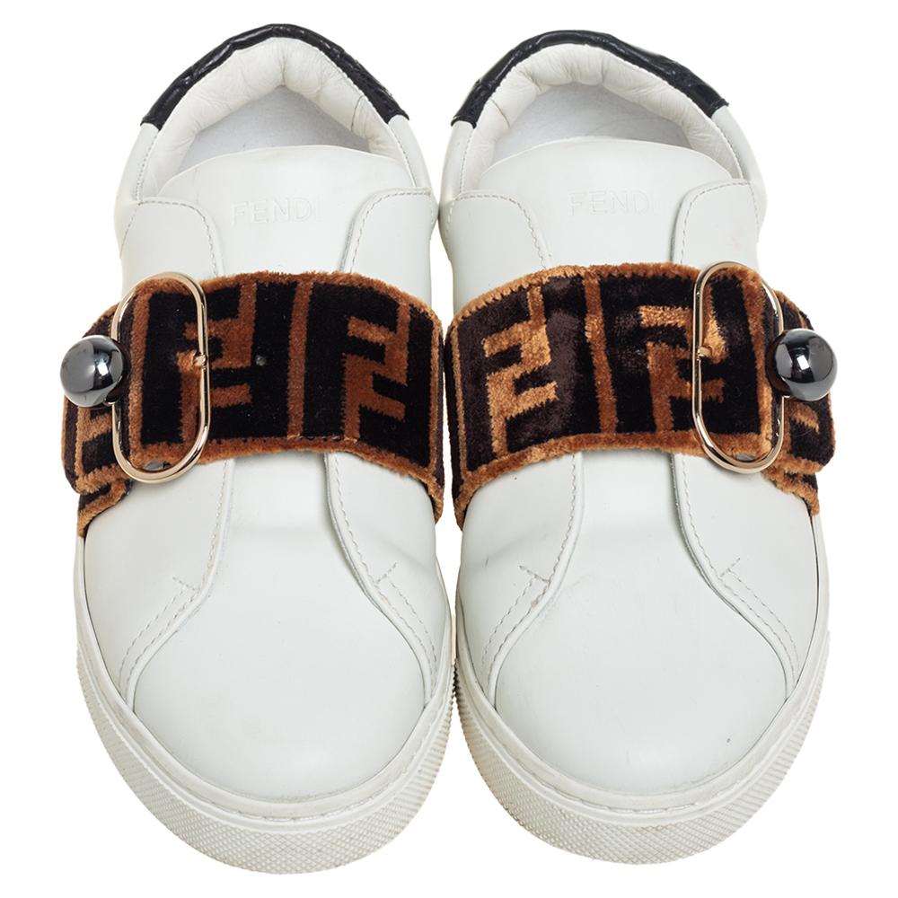 Flaunt your love for fashion by wearing these amazing slip-on sneakers from Fendi. They are expertly crafted from leather and feature the signature Zucca pattern detailed on the velvet straps on the vamps. They are endowed with comfortable